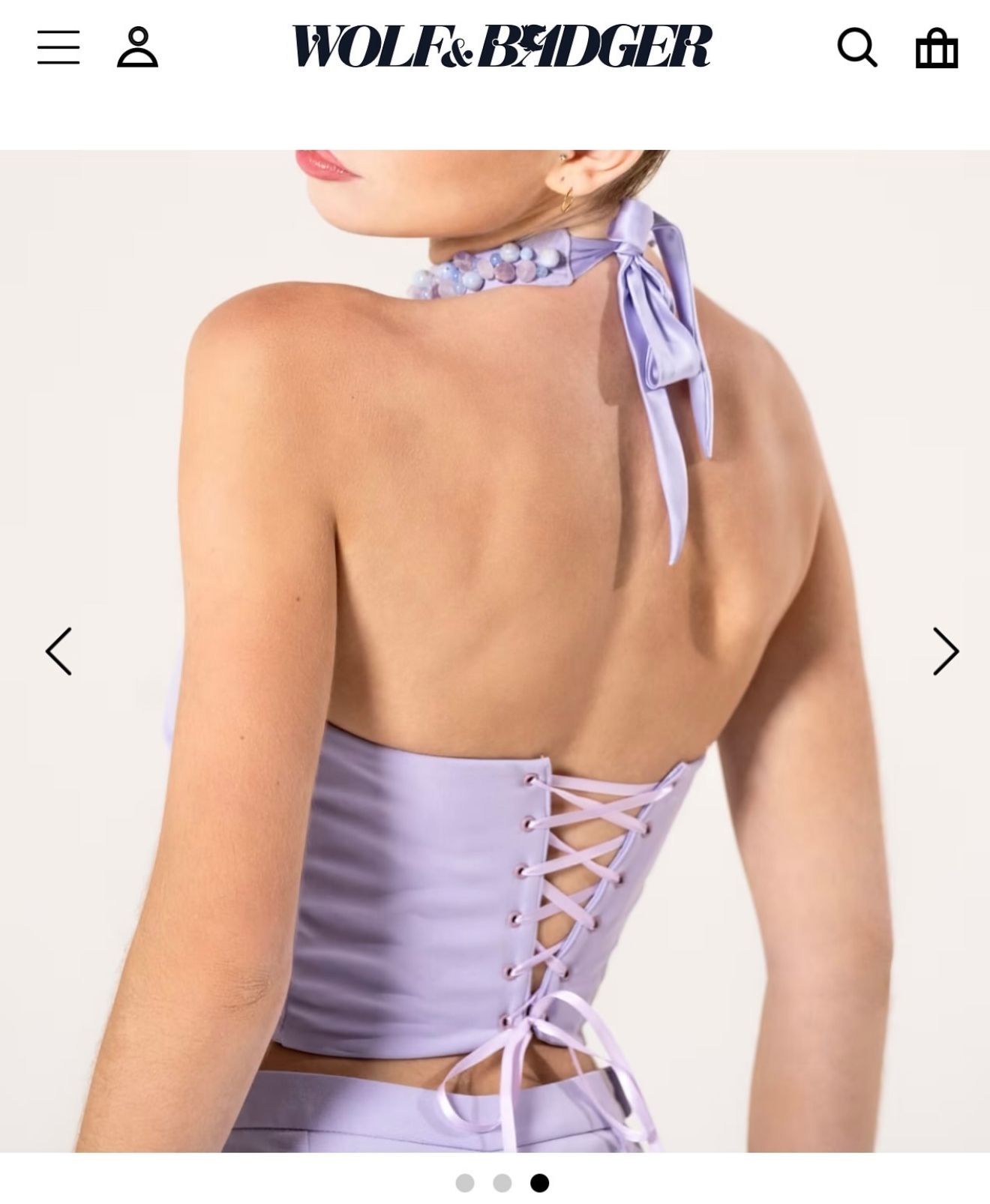 Lavender halter corset crop top with lace-up back detail and bow tie neck, shown from behind on model.