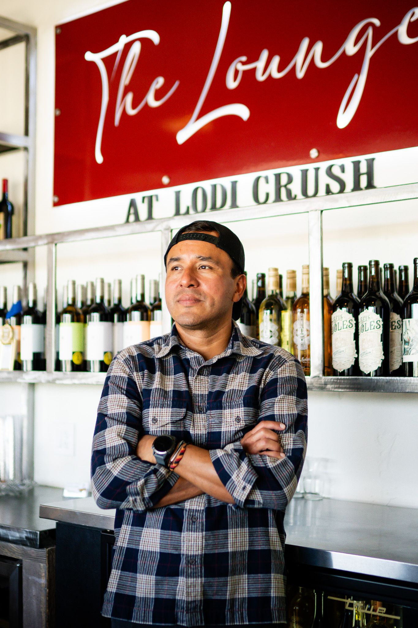 Interior view of a wine bar with multiple black and white photos arranged showing someone in a plaid shirt.