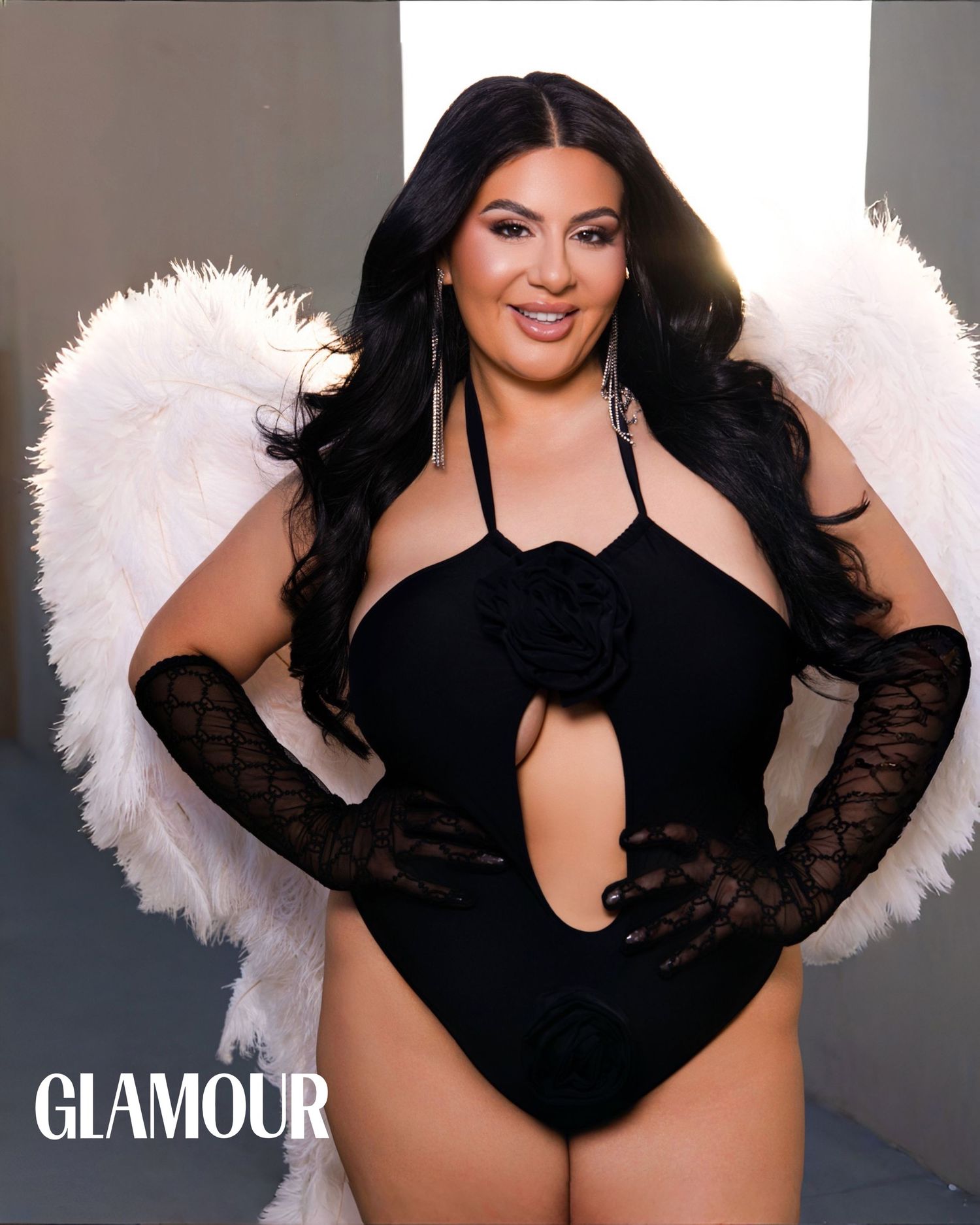 Woman in black bodysuit with white angel wings poses for Glamour magazine cover shoot.