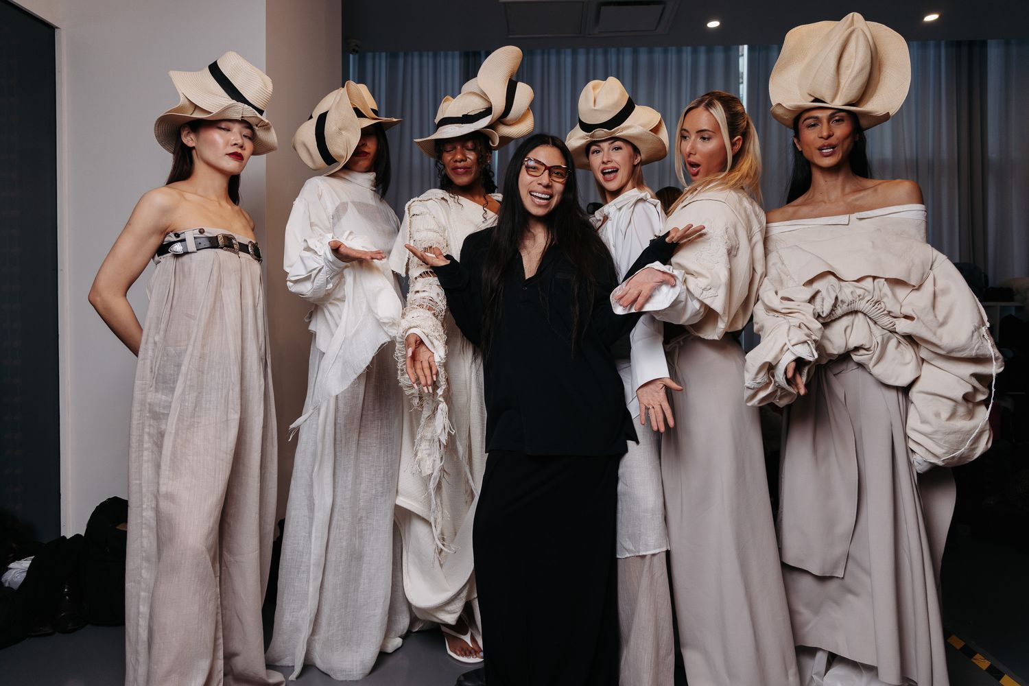 Group fashion photo featuring models in coordinated white and cream colored outfits.