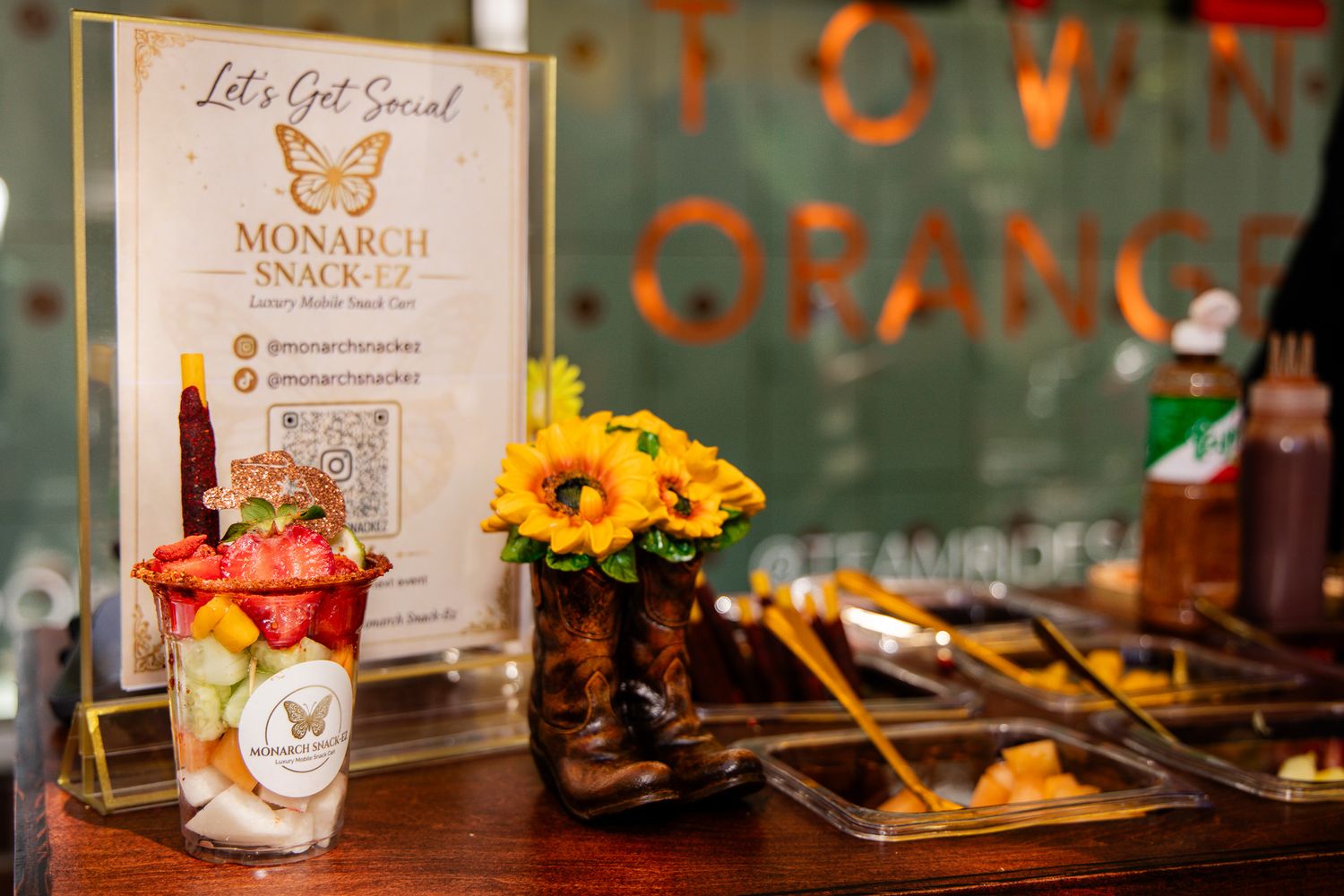 Elegant restaurant table settings with sunflowers and appetizers displayed on wooden serving boards.