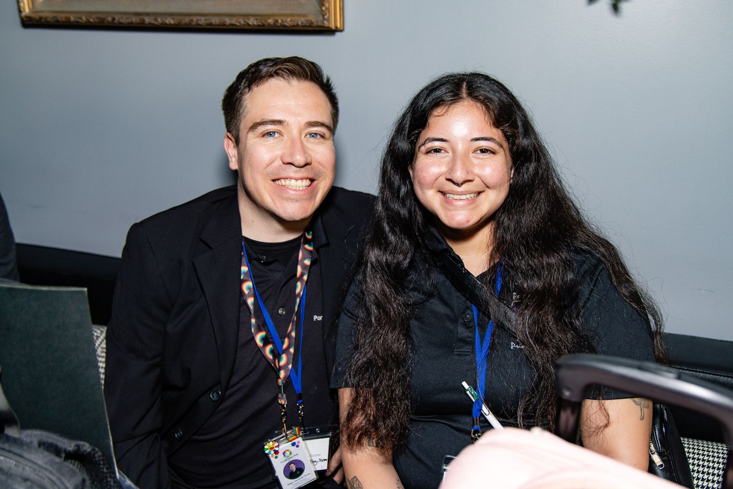 People in black attire posing together at what appears to be a professional event or conference.