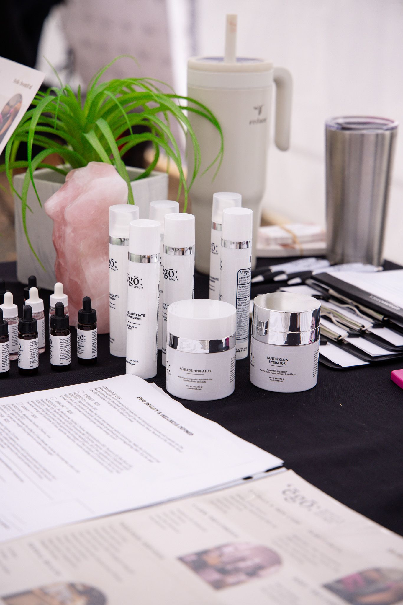 Professional skincare products and cosmetics arranged on a white display table with documents.