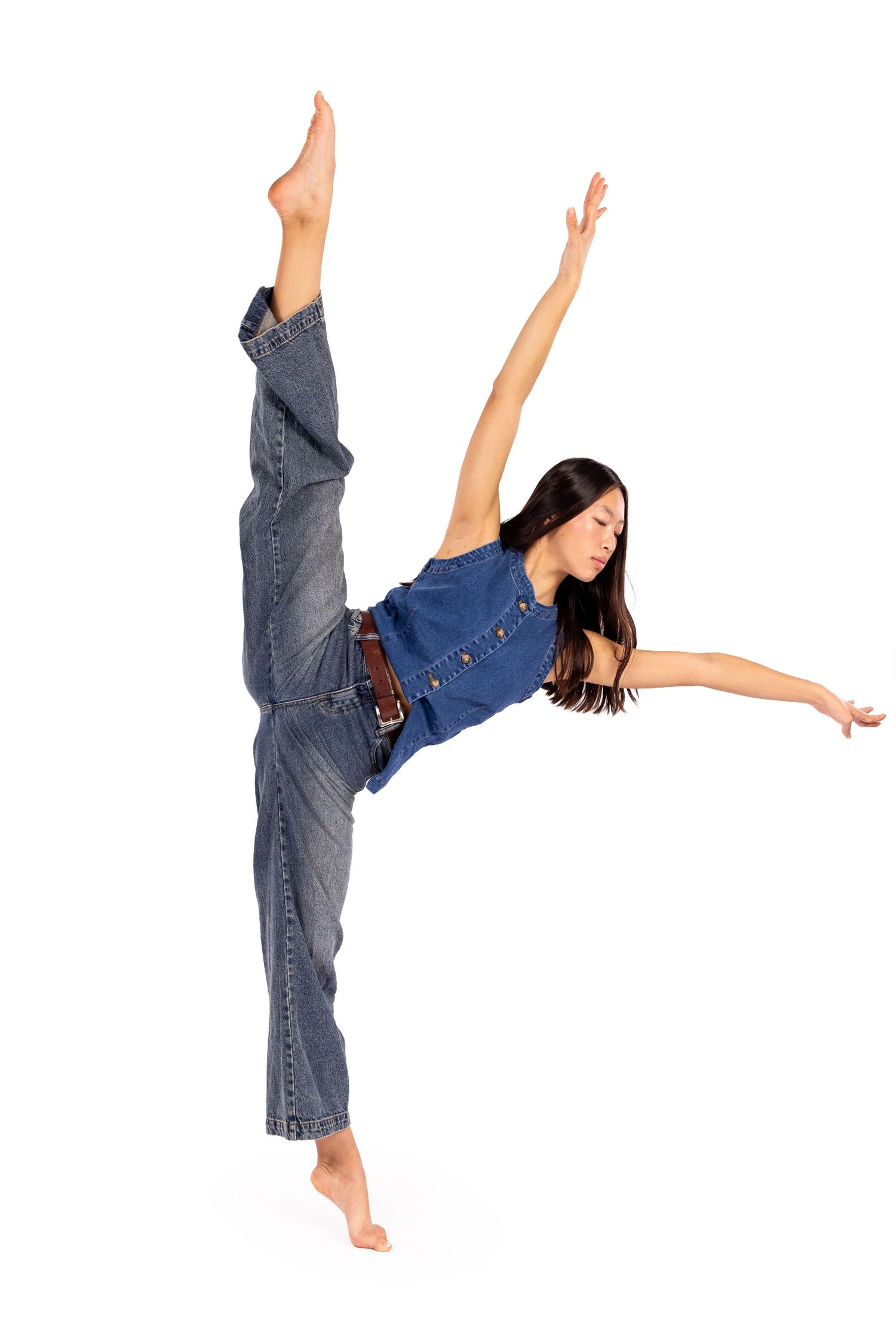 A dancer in denim performs a graceful high kick sequence against a white background.