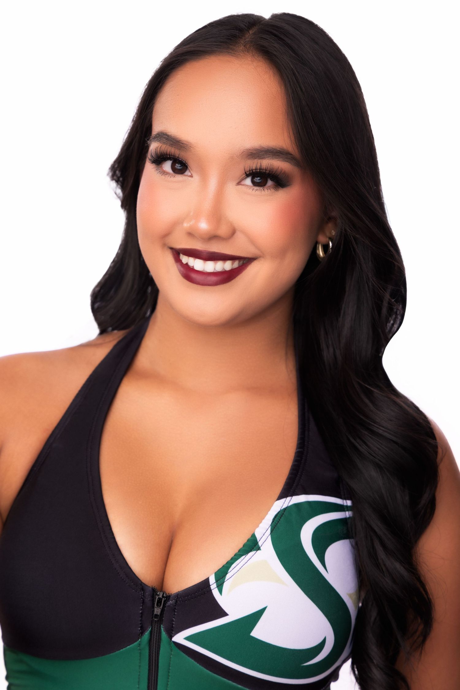 Professional beauty shots in black and green sports top with wavy dark hair.