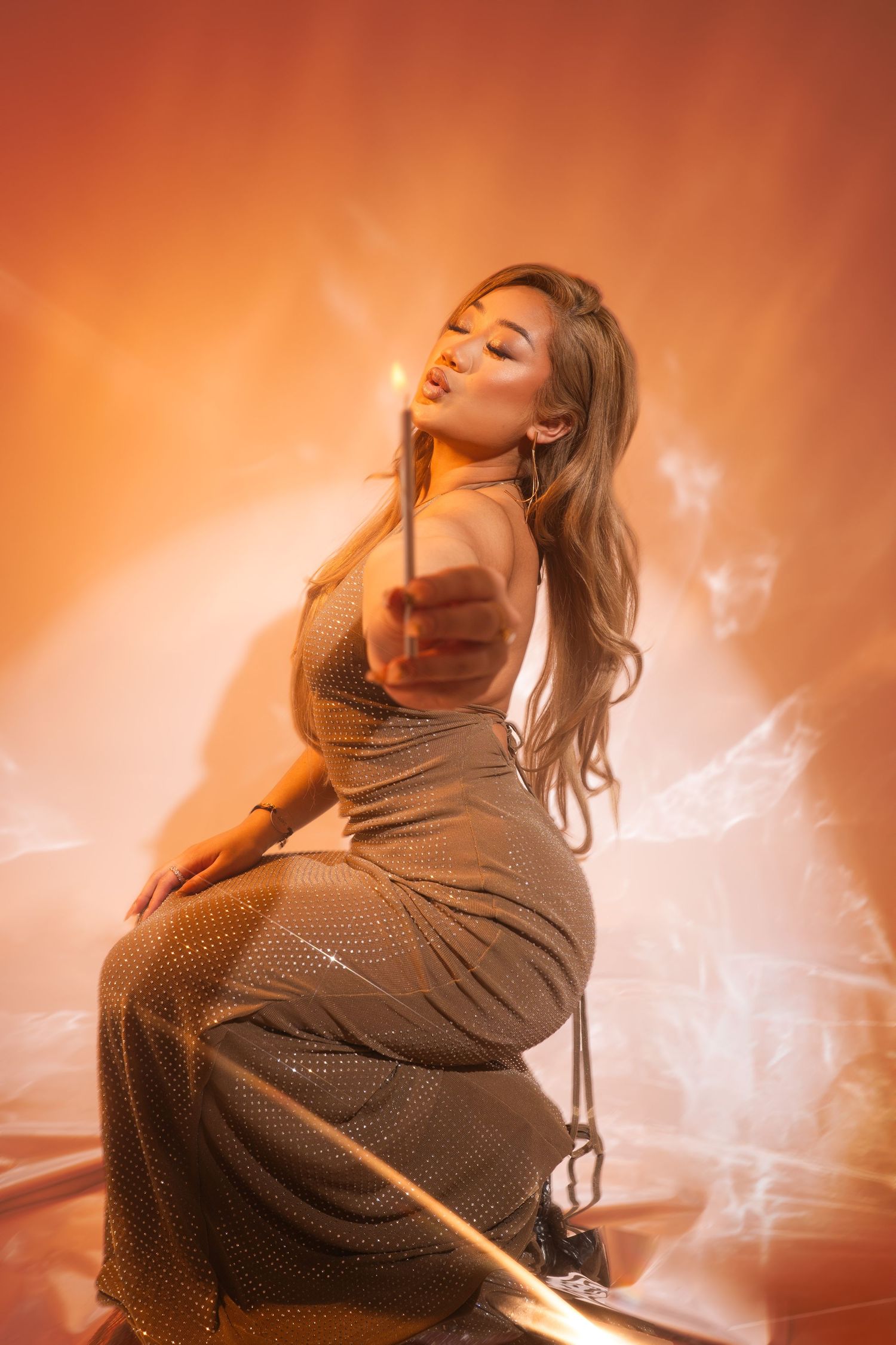 Silhouetted performer in a dramatic orange-lit stage setting creating an atmospheric performance moment.