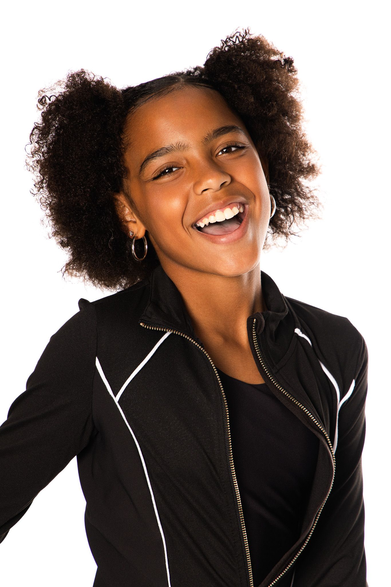 Portrait of a person with natural curly hair wearing a black jacket with white trim.