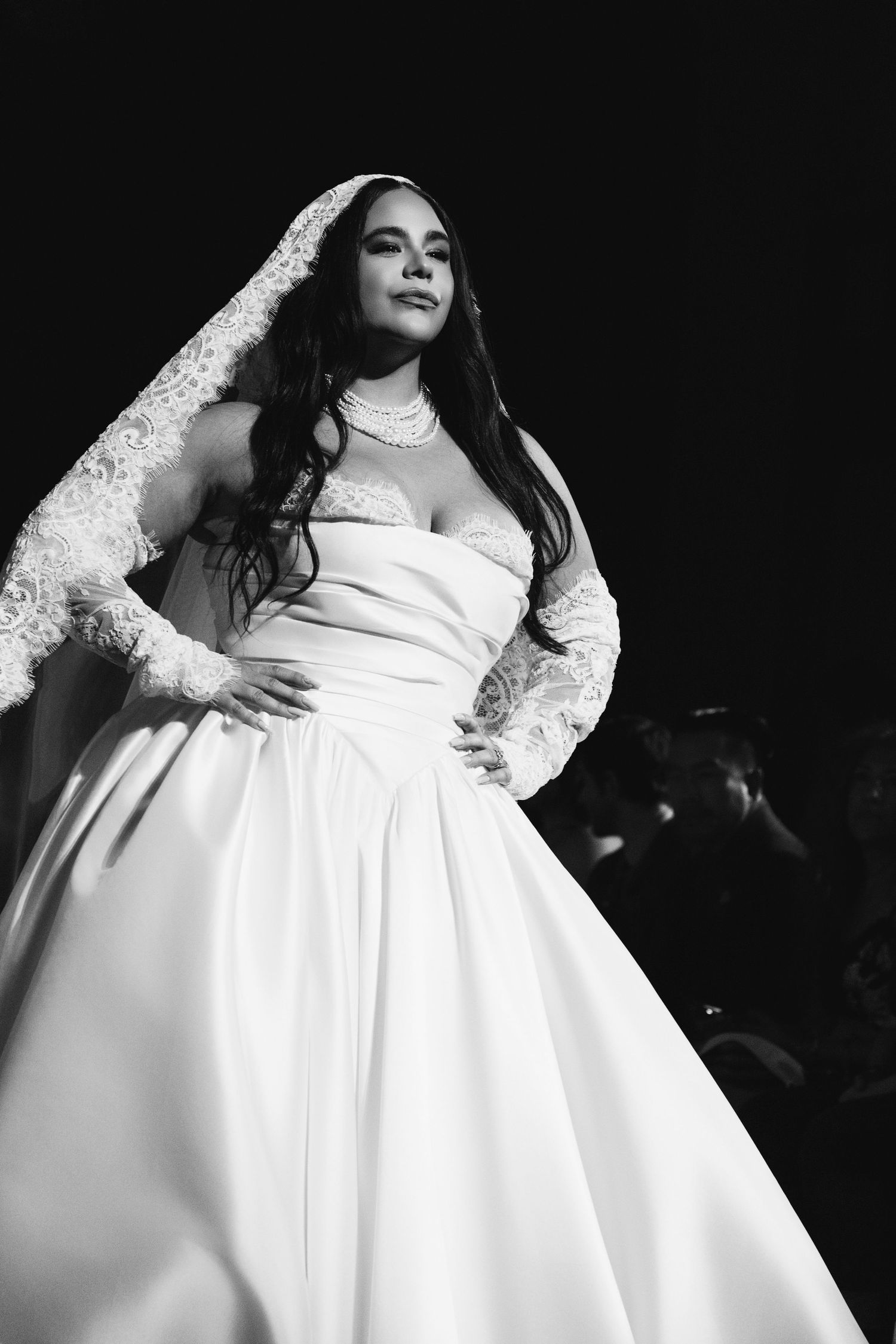 A series of black and white photos showing someone in an elegant white wedding gown with lace sleeves and full skirt.