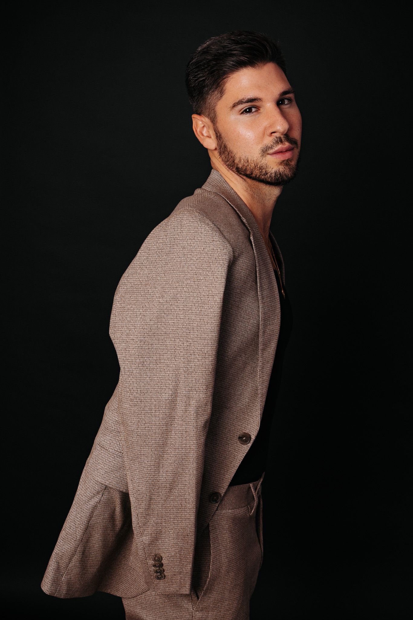 Professional fashion portrait series showcasing a brown winter coat against dark background in multiple angles.