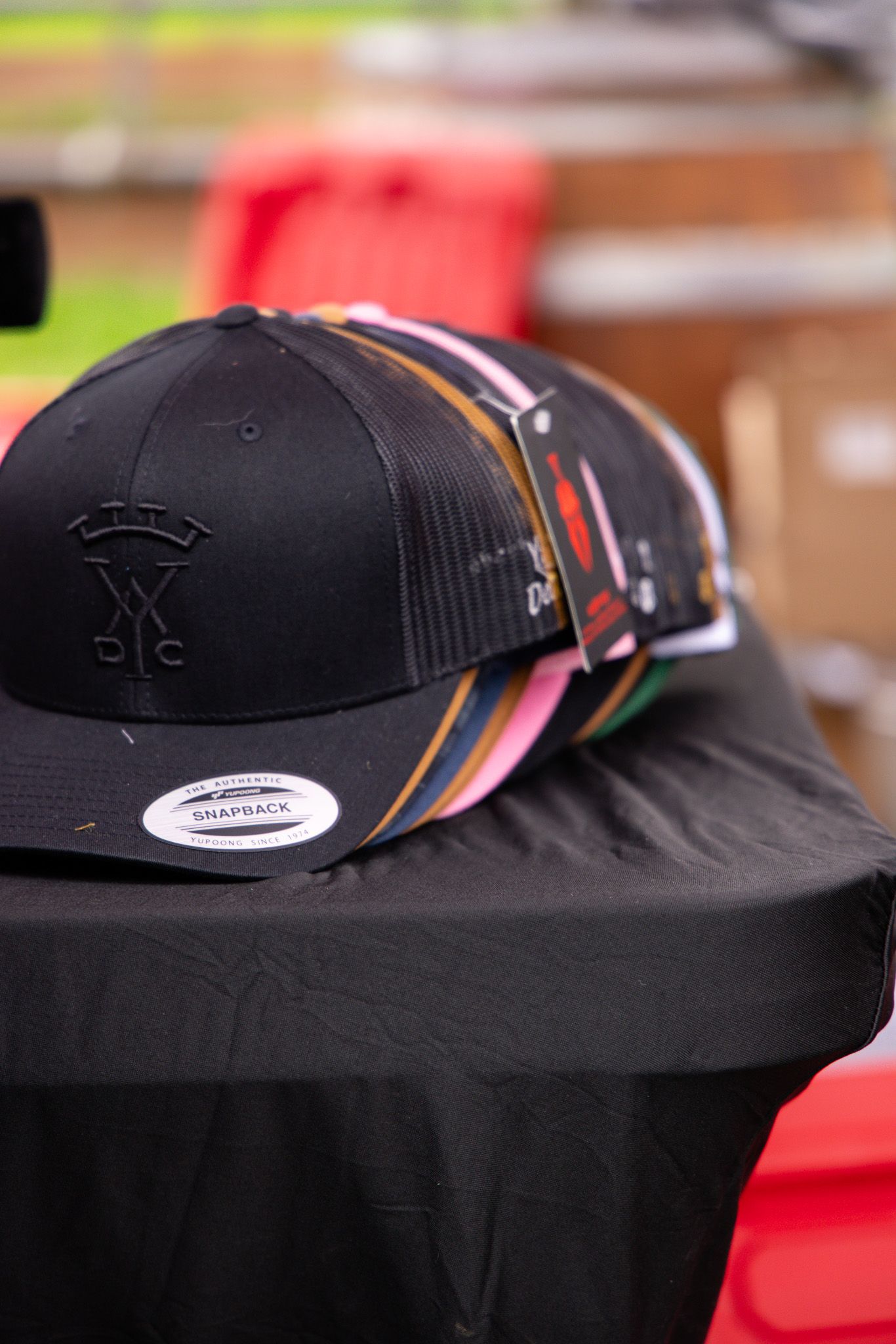 Row of black snapback hats displayed at a merchandise booth or retail setting.