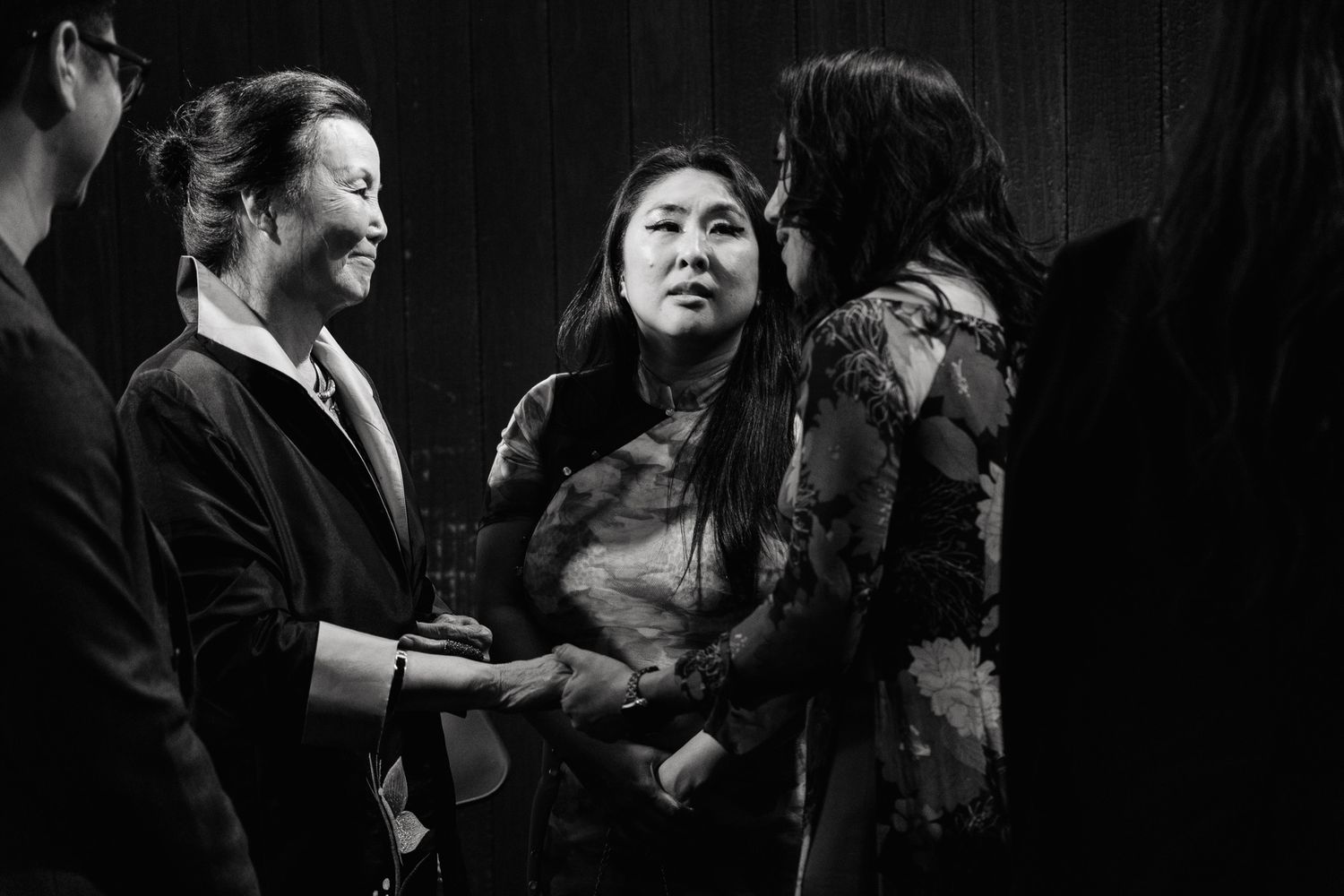 Black and white candid shot of attendees engaged in conversation at an evening event.
