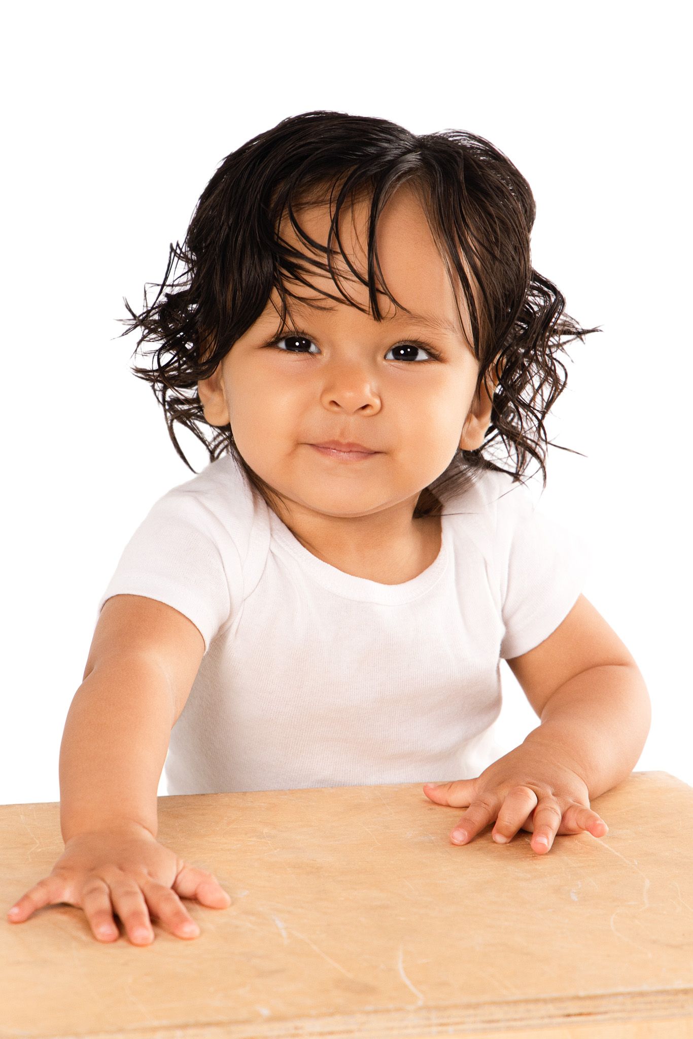 A sequence of three photos showing a small child peering over a wooden table surface from different angles.