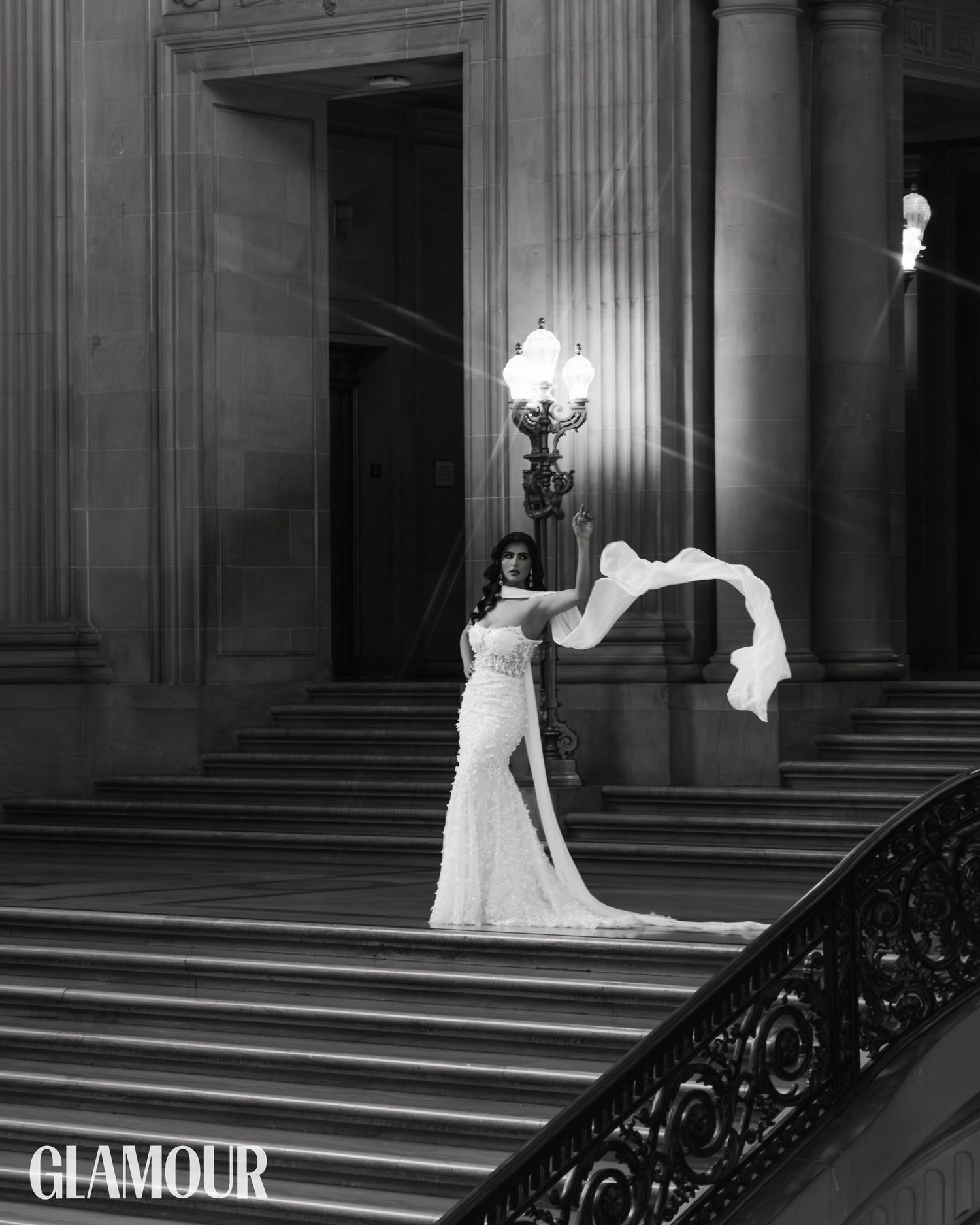 A black and white photo series shows a figure in an elegant white gown descending a grand staircase in a luxurious setting.