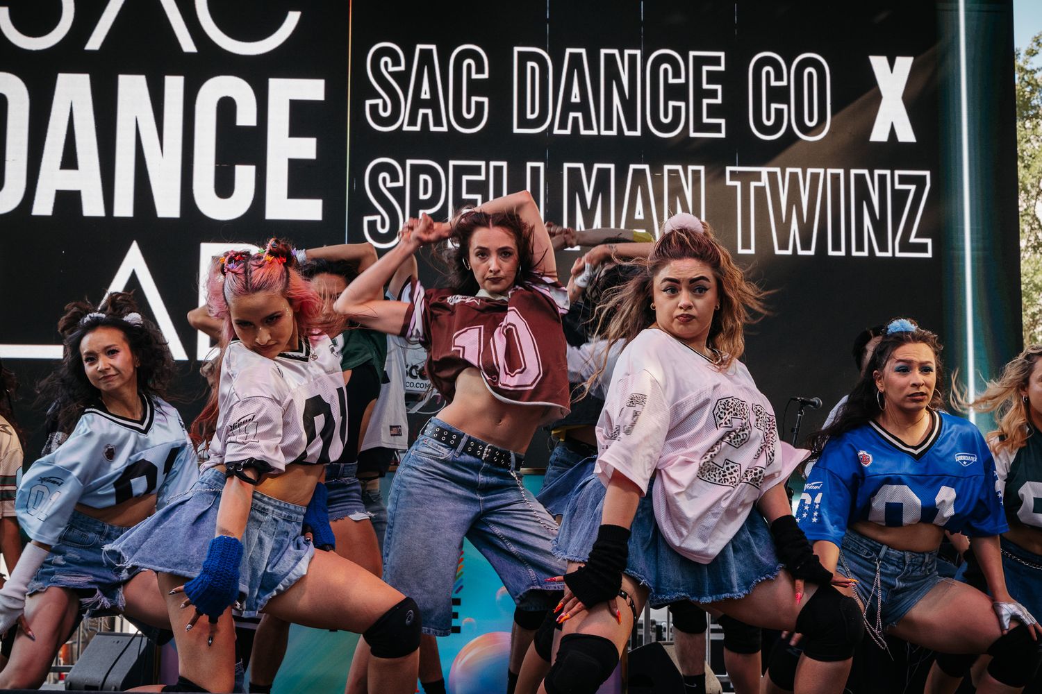 A large crowd of dance performers on stage during a high-energy performance at SAC Dance Co show.