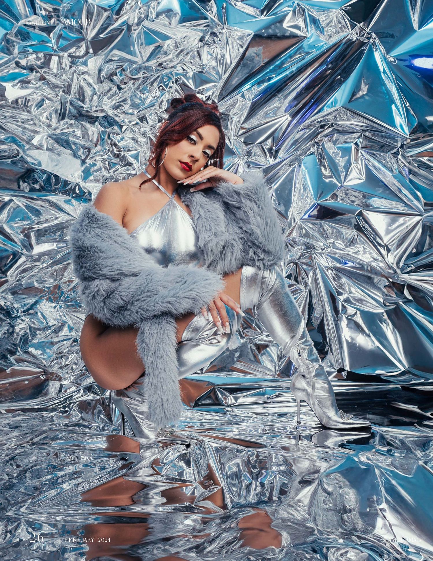 Fashion editorial with metallic backdrop and grey fur coat creating icy winter aesthetic.