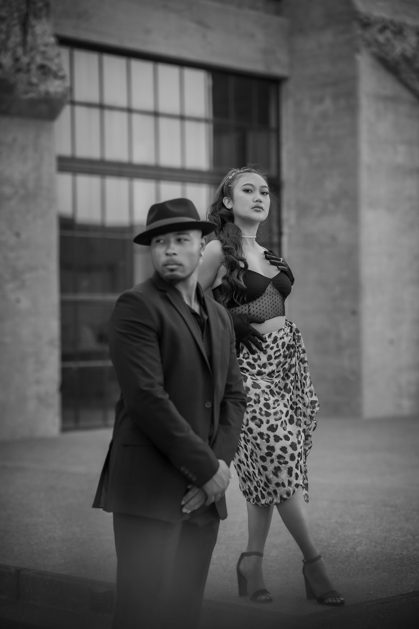 A dramatic black and white photo series showing a couple dancing together in an artistic sequence against an urban backdrop.