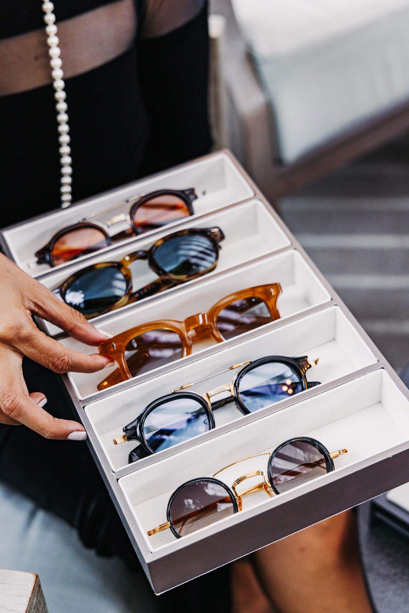 A collection of luxury sunglasses displayed in white retail trays being shown in a sequence of similar photos.