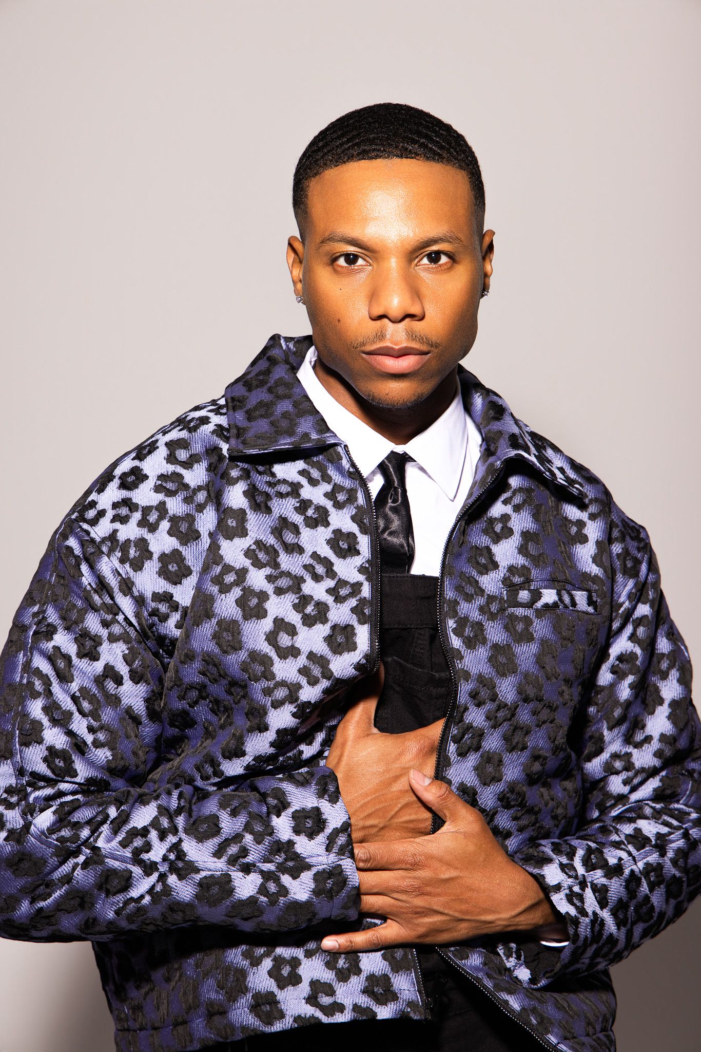 Series of fashion photos showing a person in a blue leopard print jacket against a light gray background.