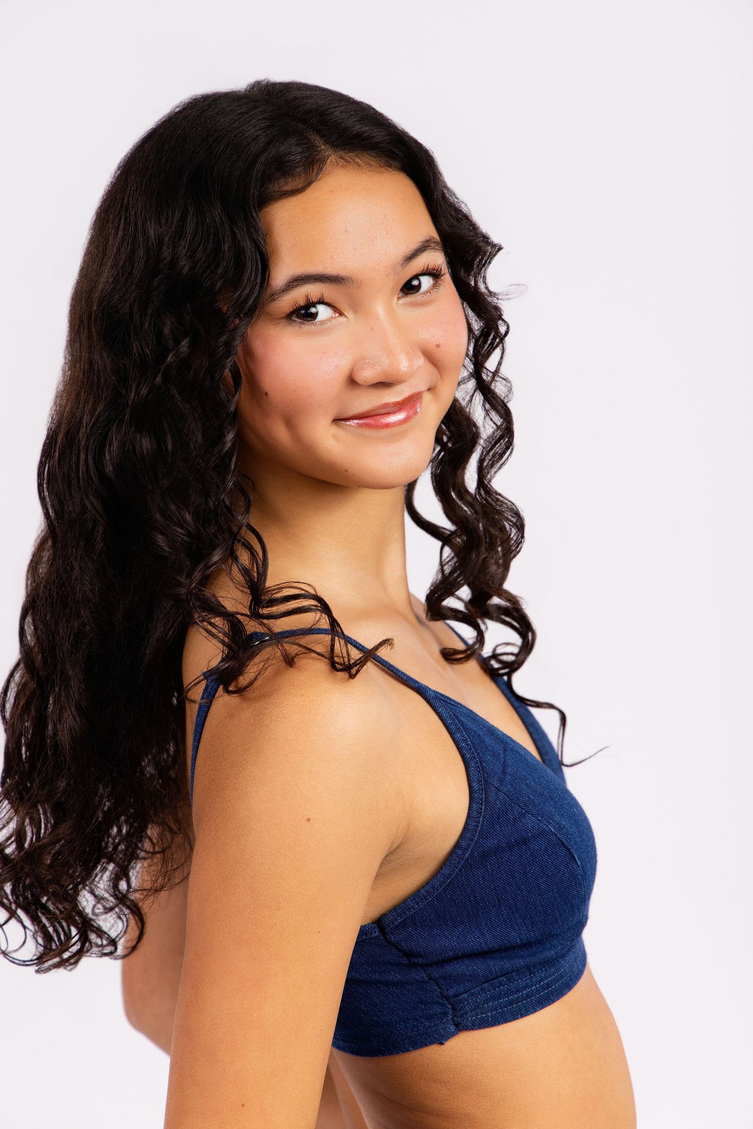 Dark-haired model in navy top poses against white background showing different angles and expressions.