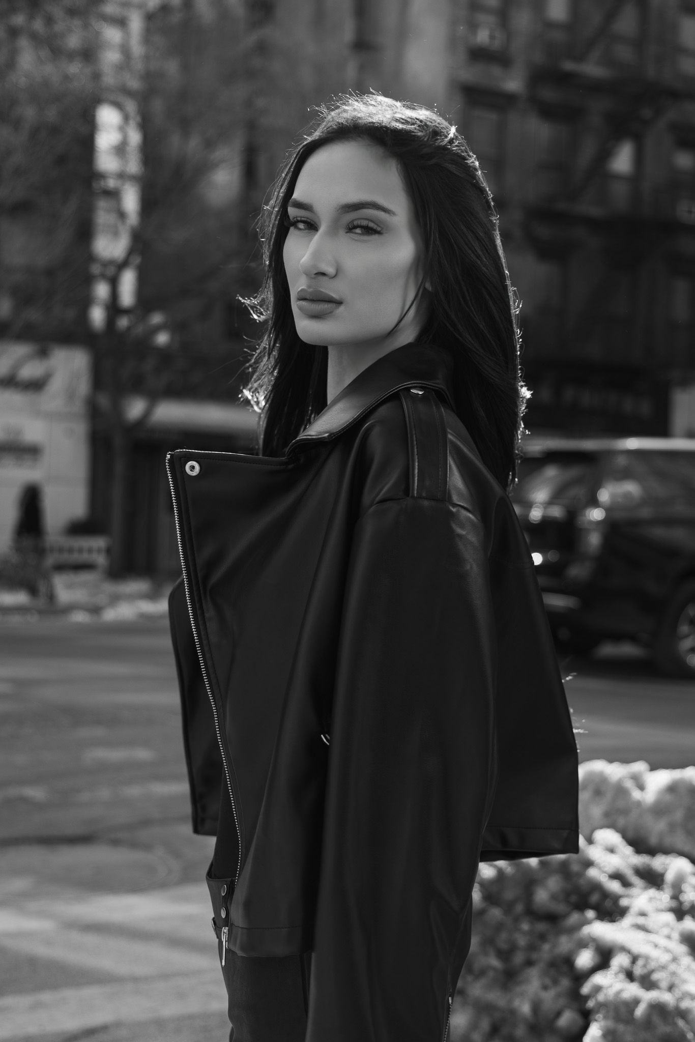 A series of black and white fashion portraits showing a woman in dark clothing against an urban background.