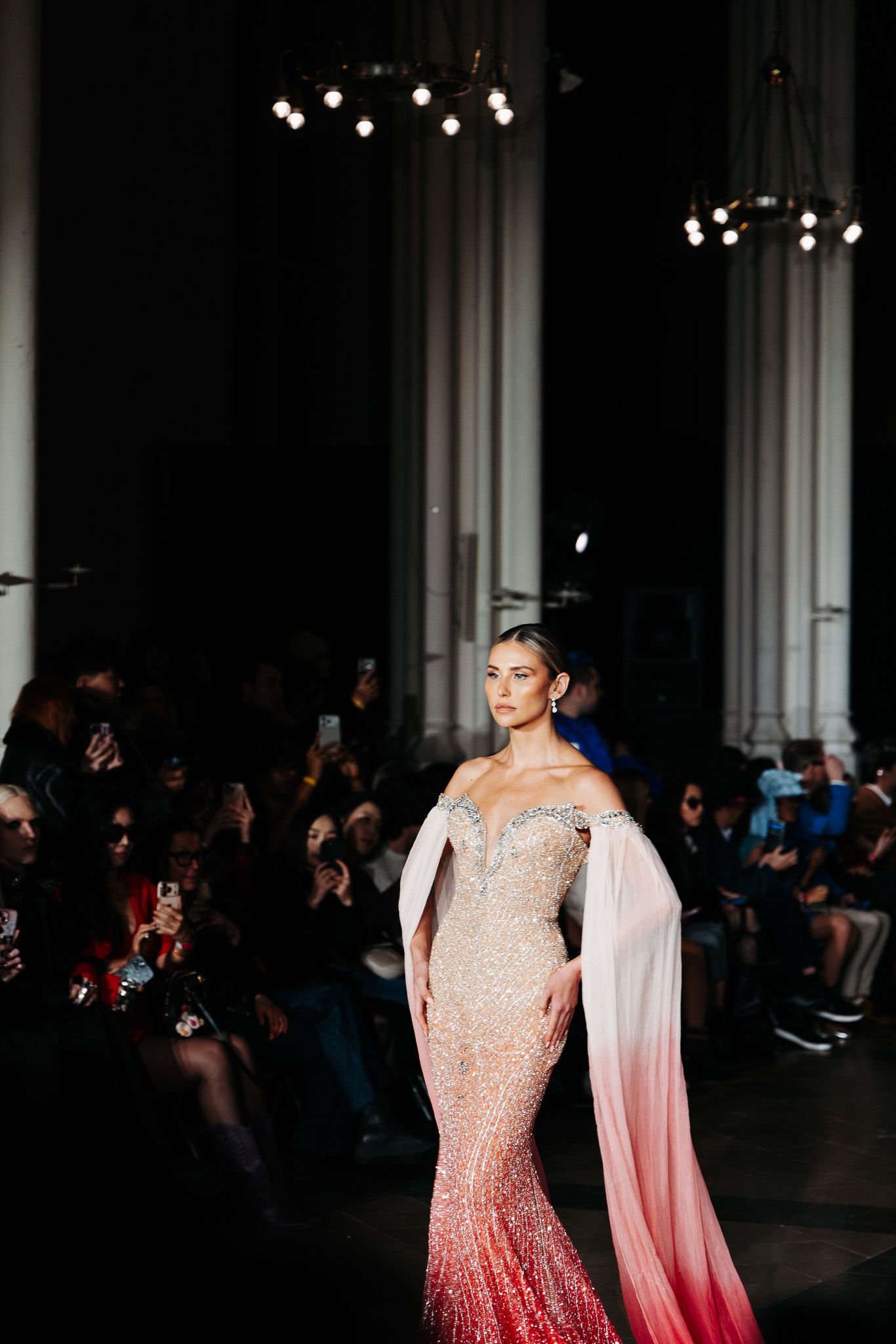 Models walk runway in sparkling ombre gowns transitioning from champagne to rose pink.