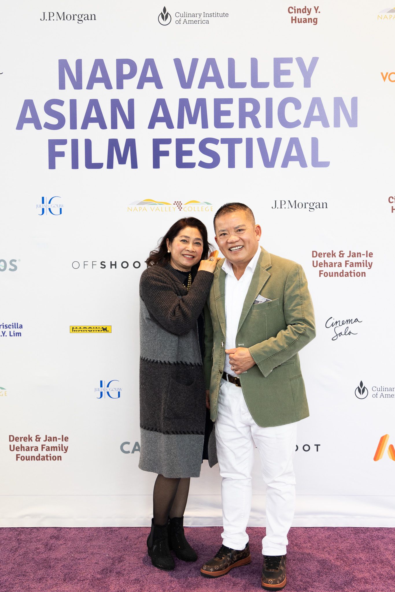Two attendees pose in front of the Napa Valley Asian American Film Festival backdrop.