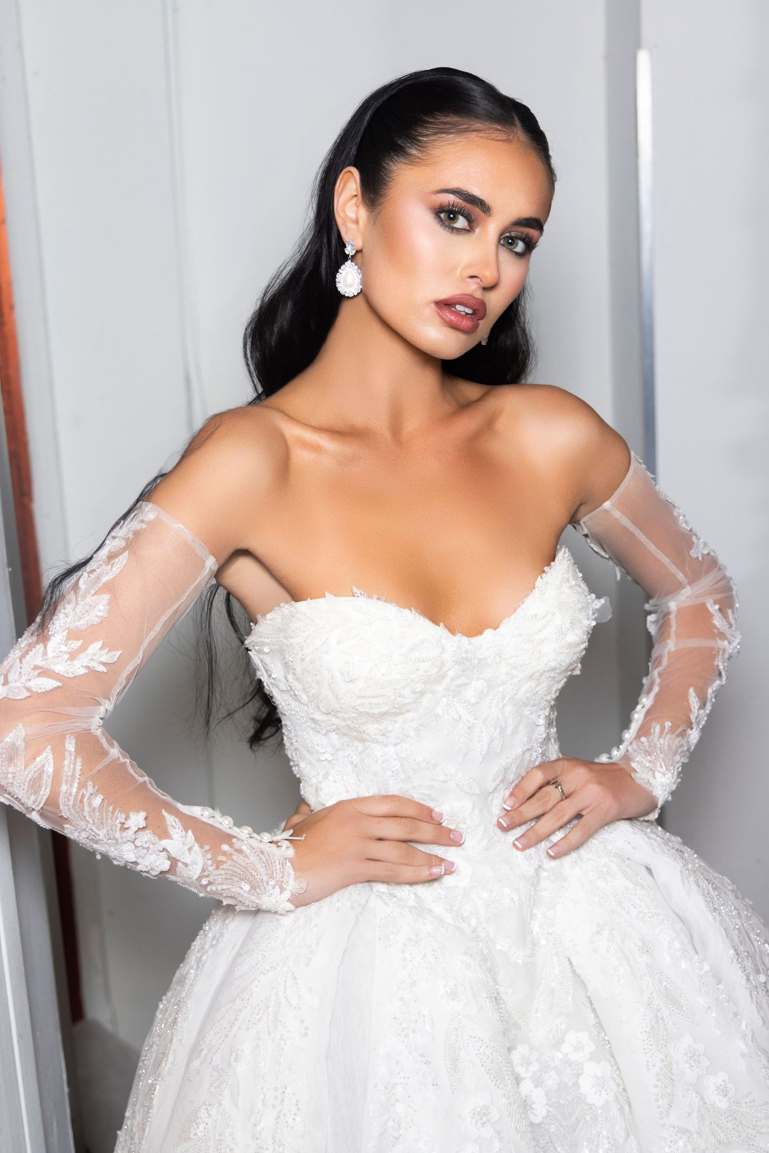 Multiple poses of a bride in an off-shoulder white wedding gown with sheer lace sleeves.