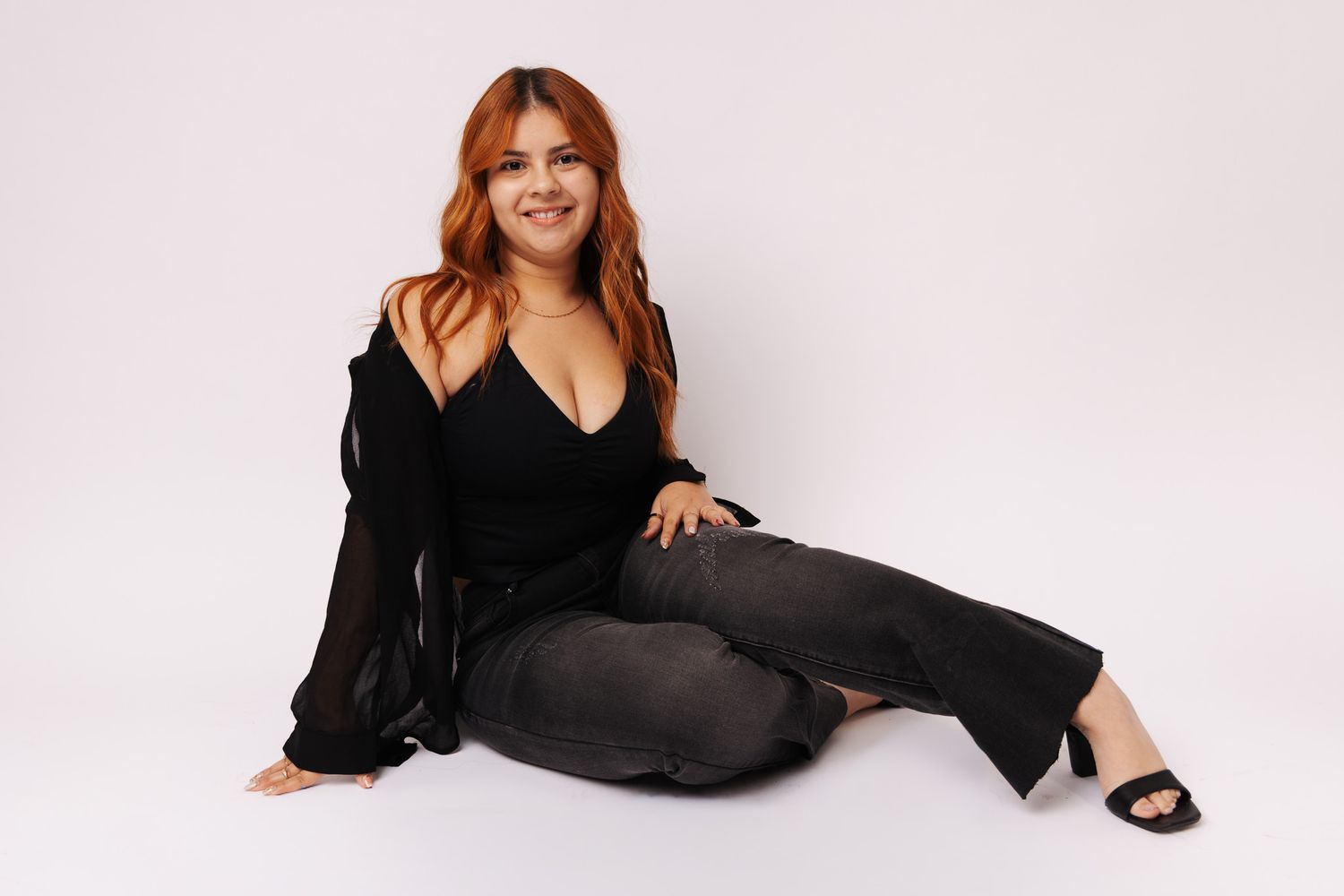 A person in a black outfit poses in different positions against a white background for a fashion photo series.