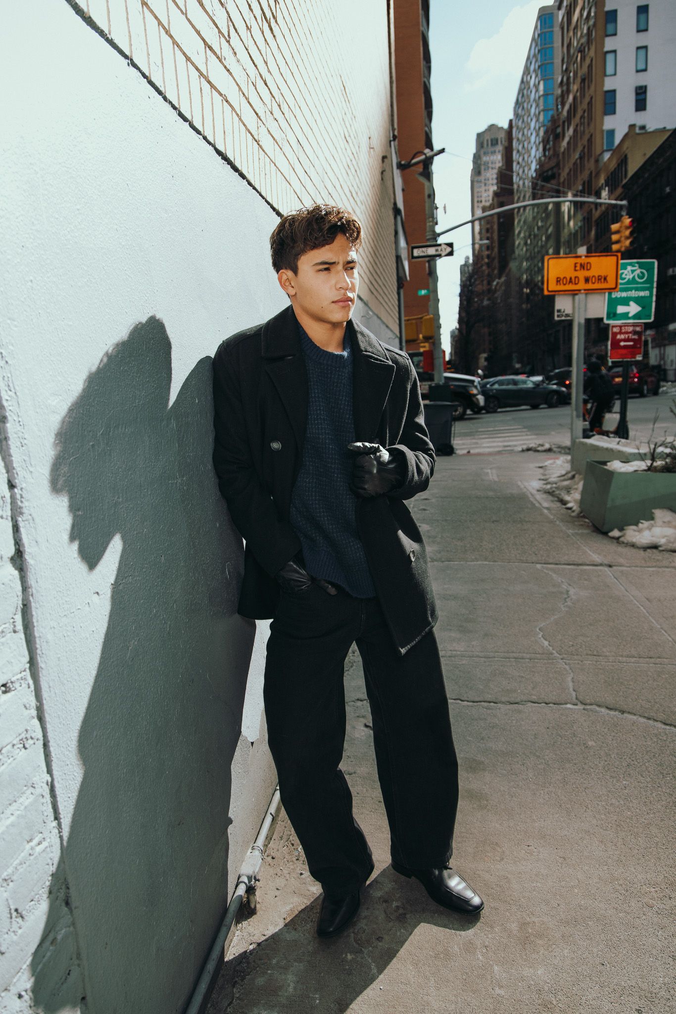A series of three street photos showing someone in dark clothing casting dramatic shadows against a white urban wall.