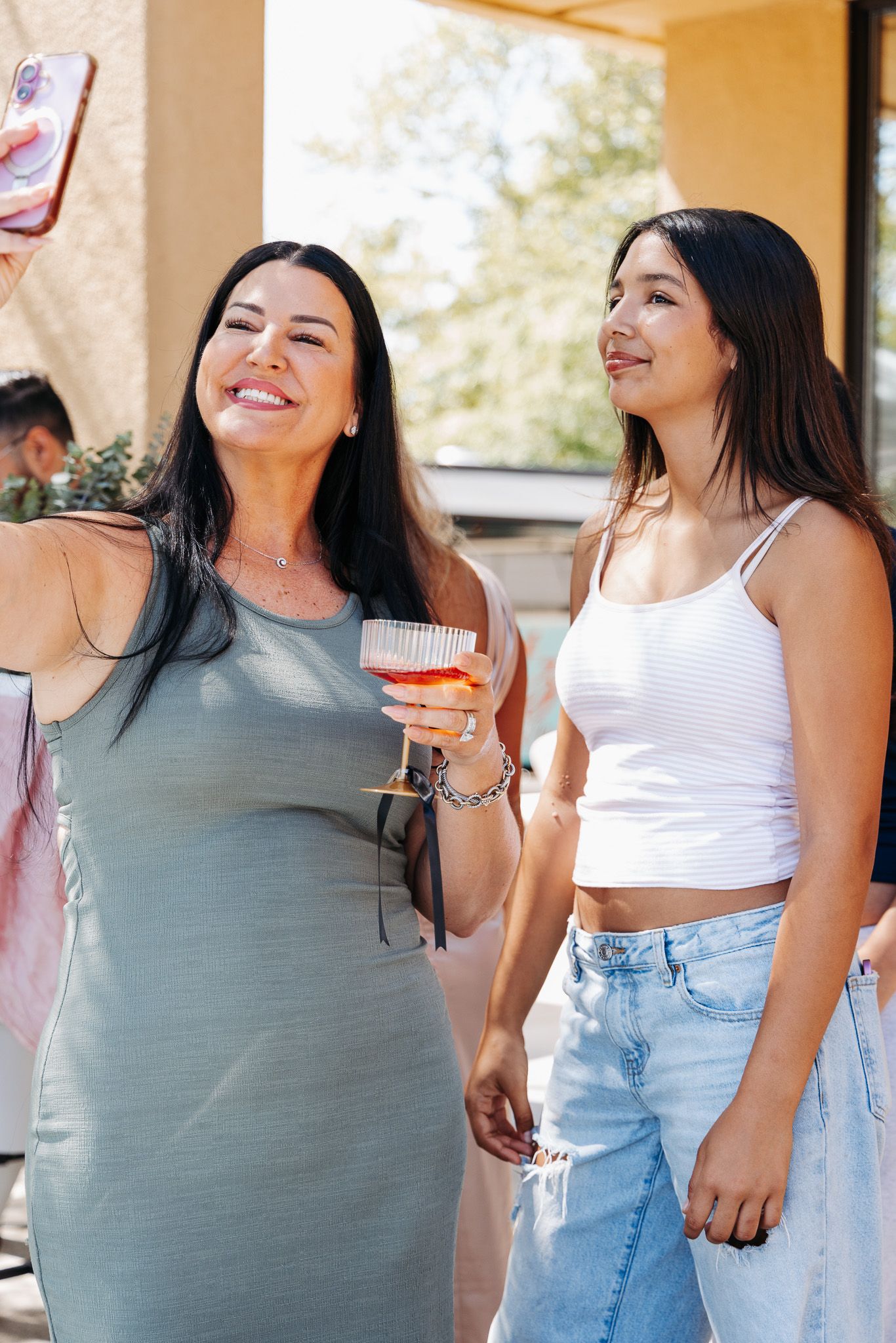A group of people in casual summer outfits standing together outdoors and smiling.