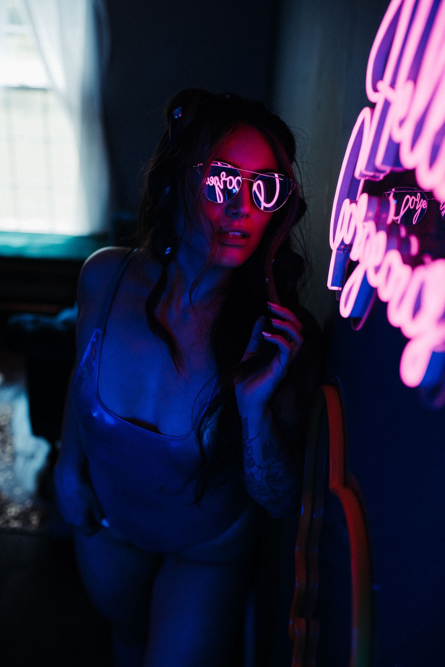 Artistic portrait with neon pink lighting creates vibrant modern atmosphere.
