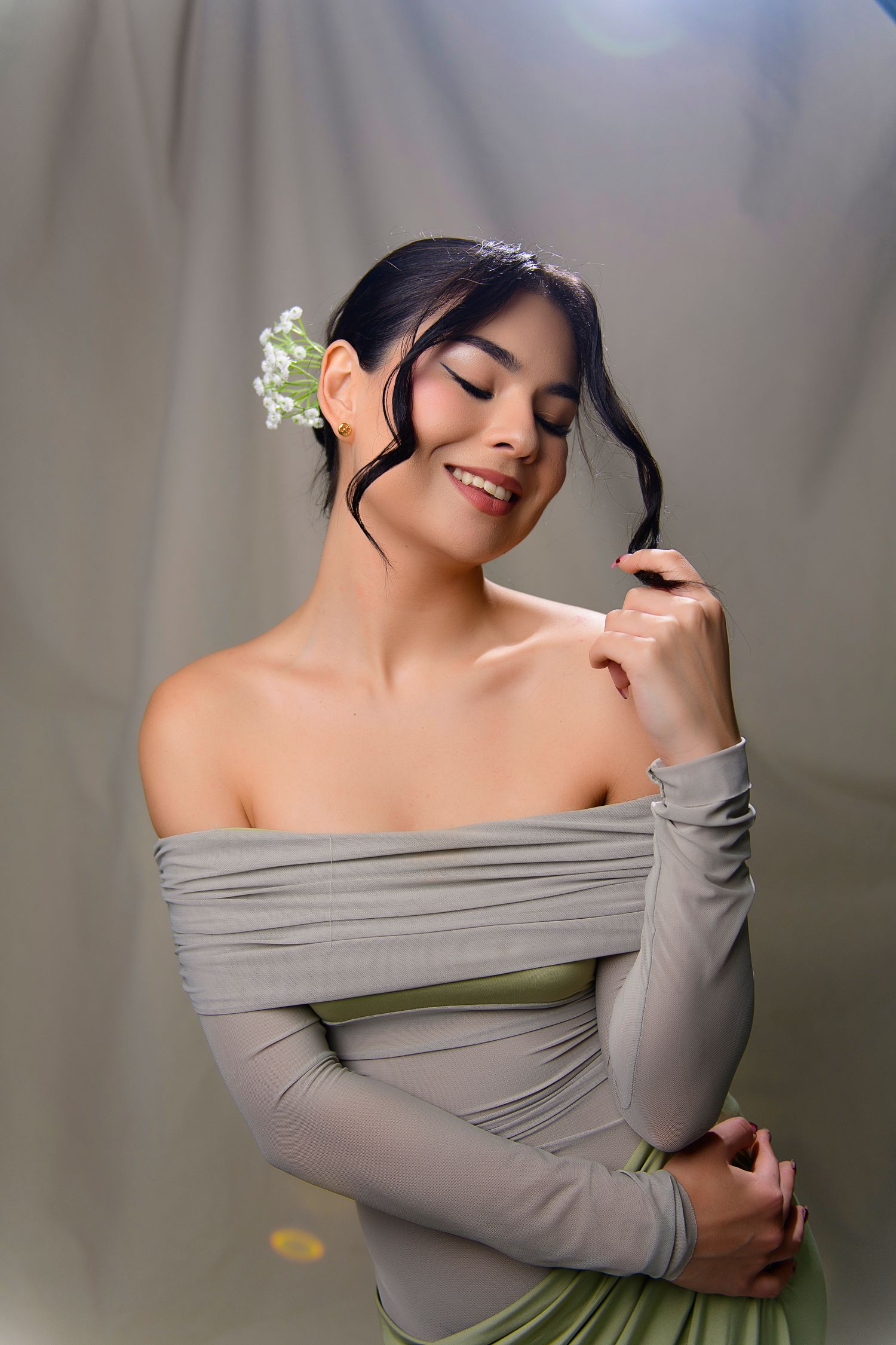 A series of artistic portrait photographs showing someone in a gray off-shoulder top with delicate white flowers in their hair.