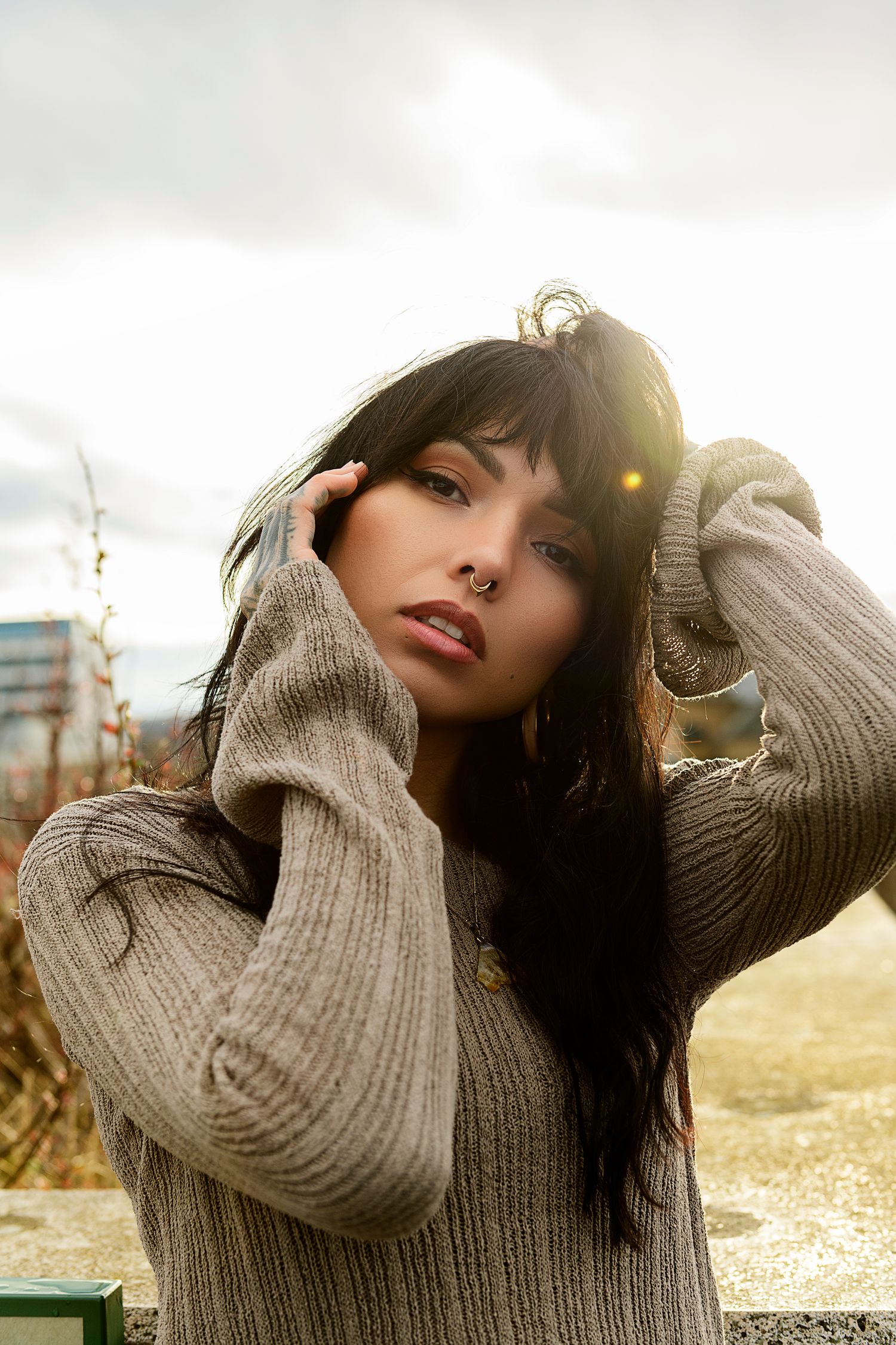 A series of five connected photos showing someone in a cozy beige sweater posing outdoors with dramatic lighting at sunset.