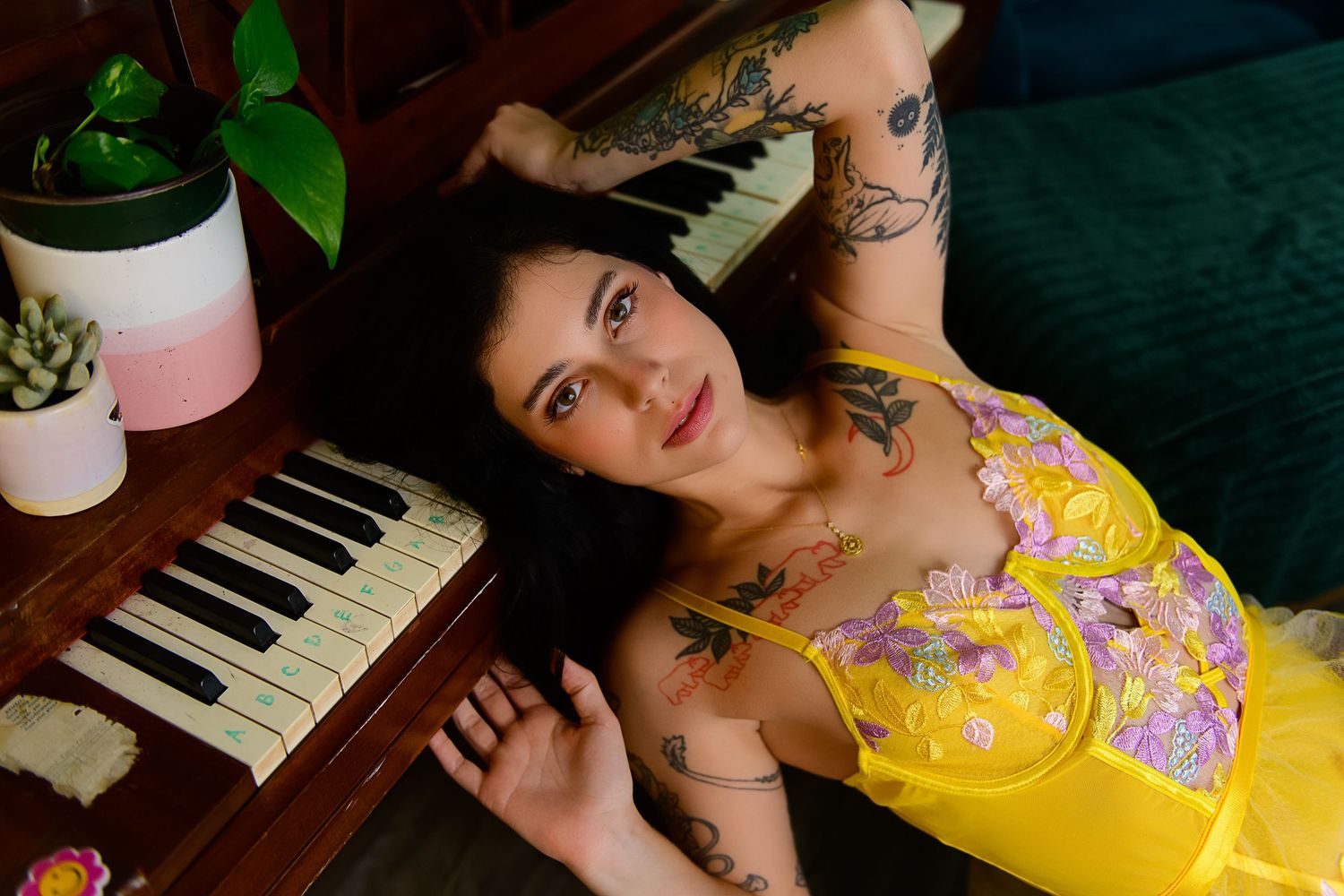 A figure in a vibrant yellow dress poses artistically near a piano in a series of dreamy portraits.