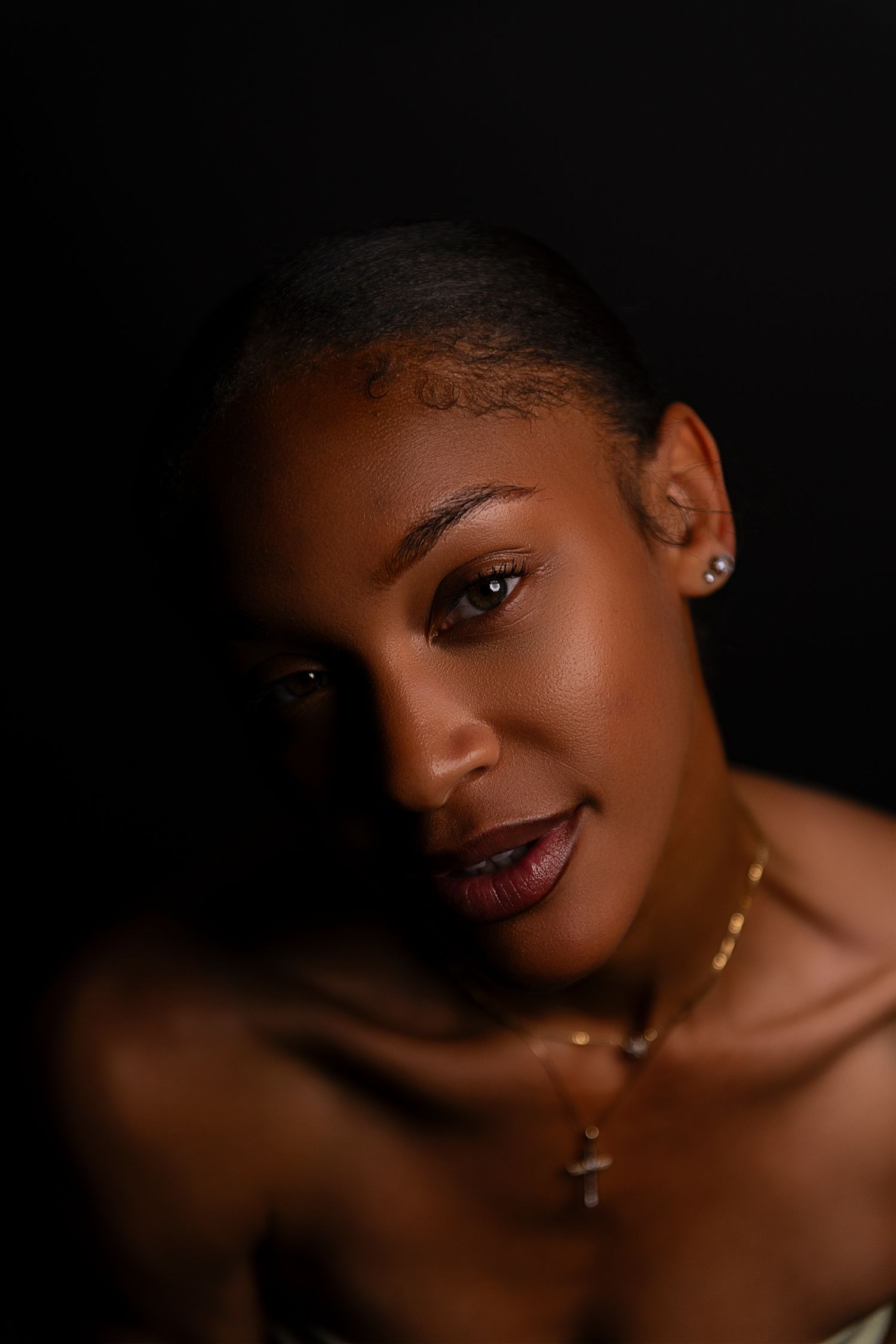 A series of artistic portrait photos with dramatic lighting against a dark background showcasing elegant jewelry and makeup.