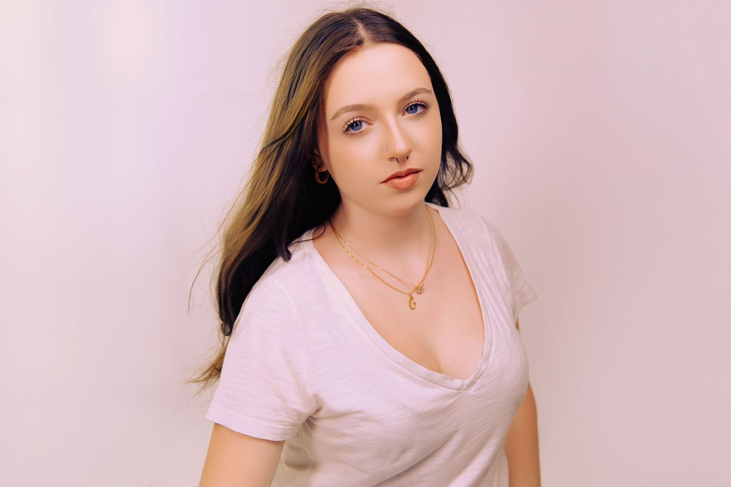 Minimalist portrait series against a soft pink background showing natural expressions.