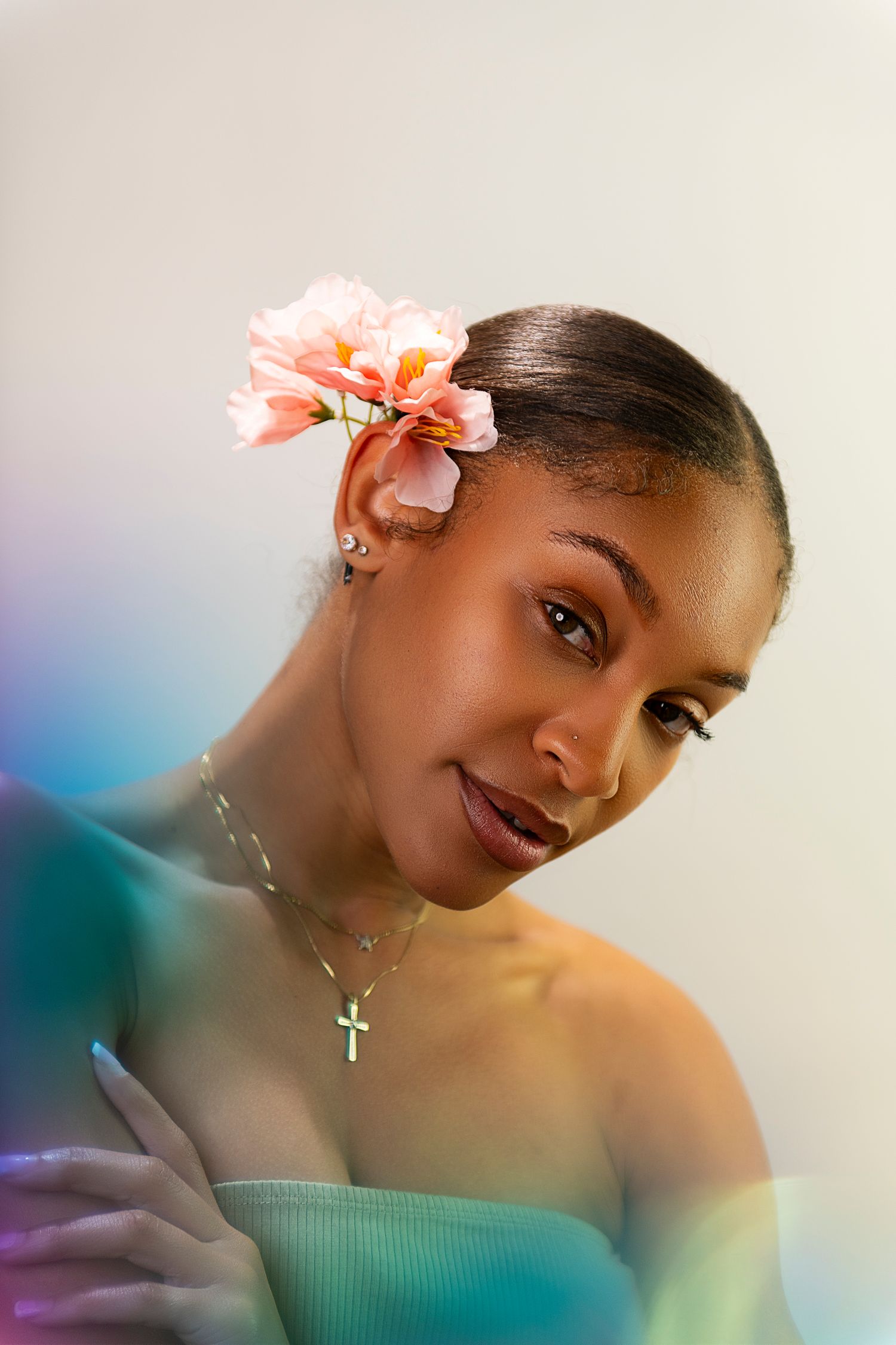 A portrait series showing a person with coral flowers in their hair against a dreamy blue and green background.