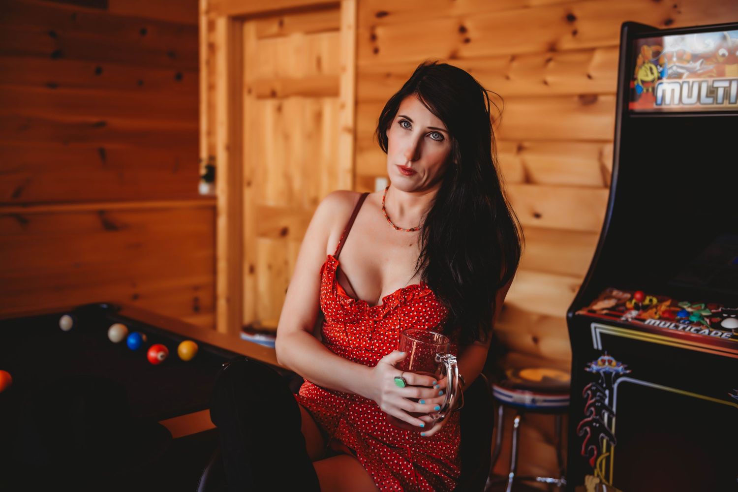 Cozy cabin boudoir photography with rustic wood paneling and warm lighting.