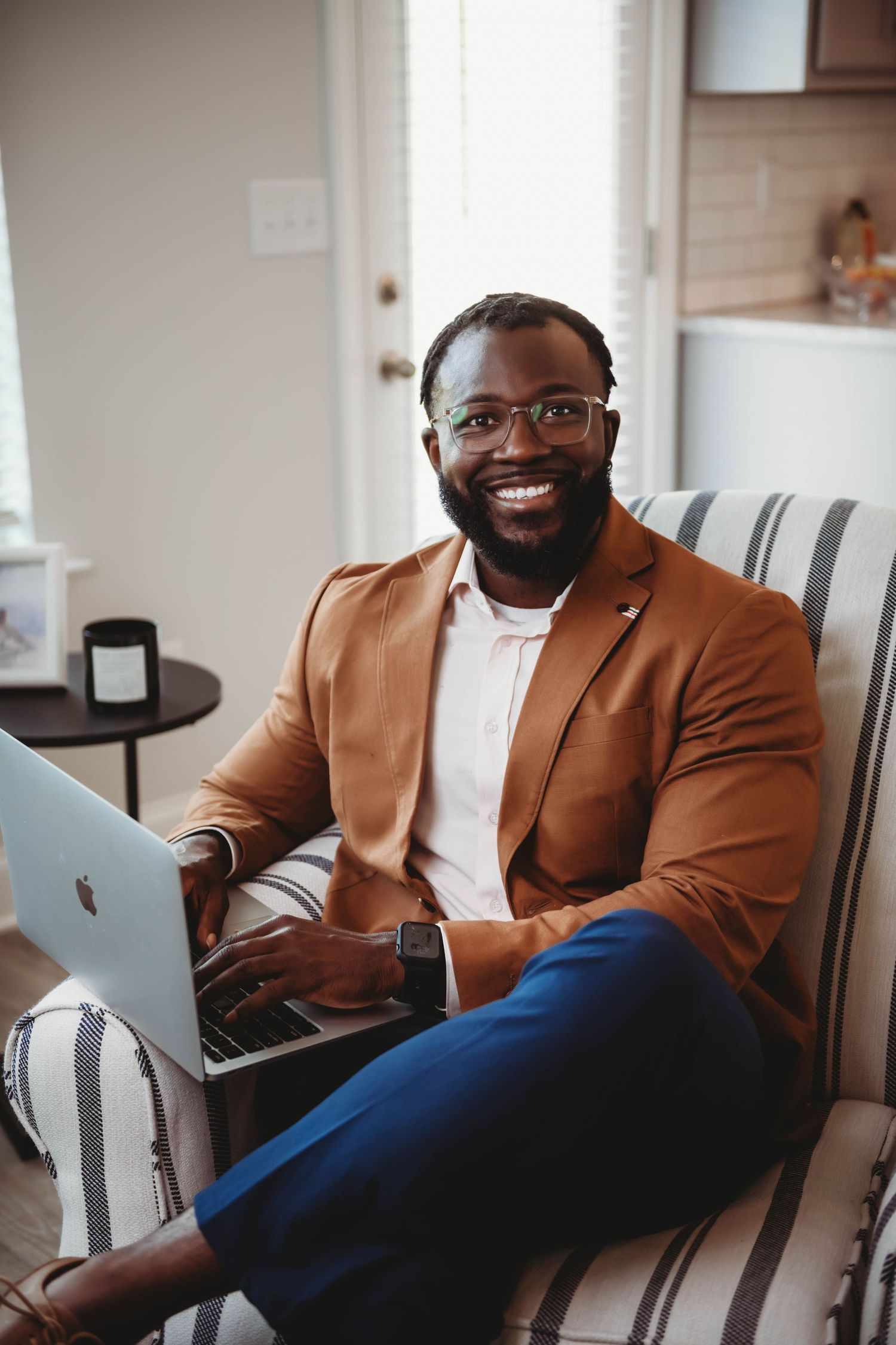 Business professional working on laptop in casual home office setting.