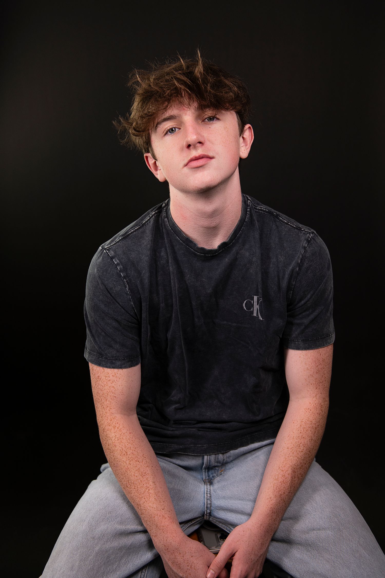 A series of portraits against a black background showing someone wearing a dark t-shirt and light colored pants.