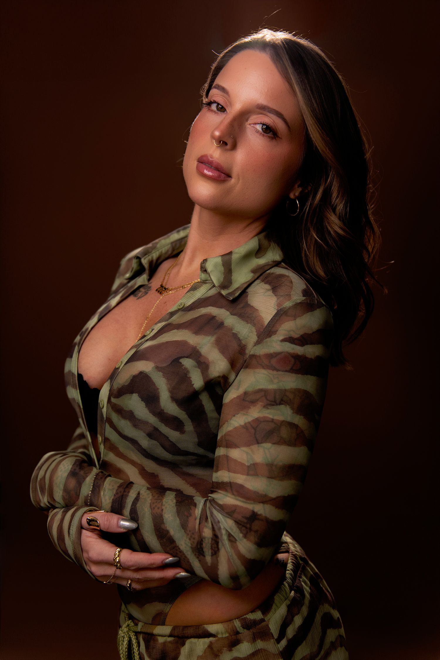 Artistic portrait series showing a model in a camouflage jacket posing against a dark brown background.