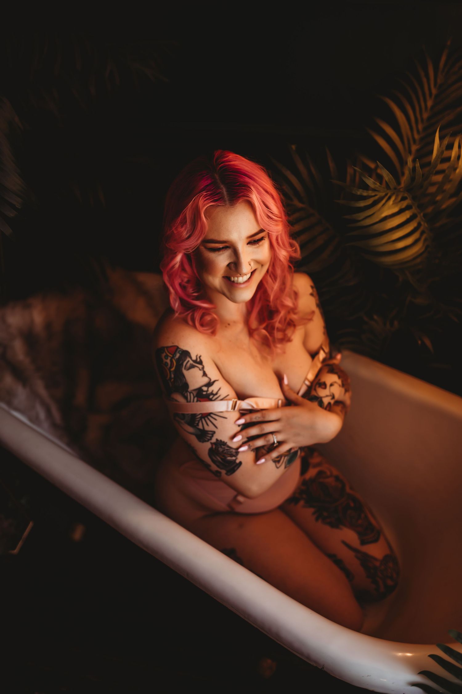 Artistic boudoir photography featuring red hair and dark shadows with palm frond accents.