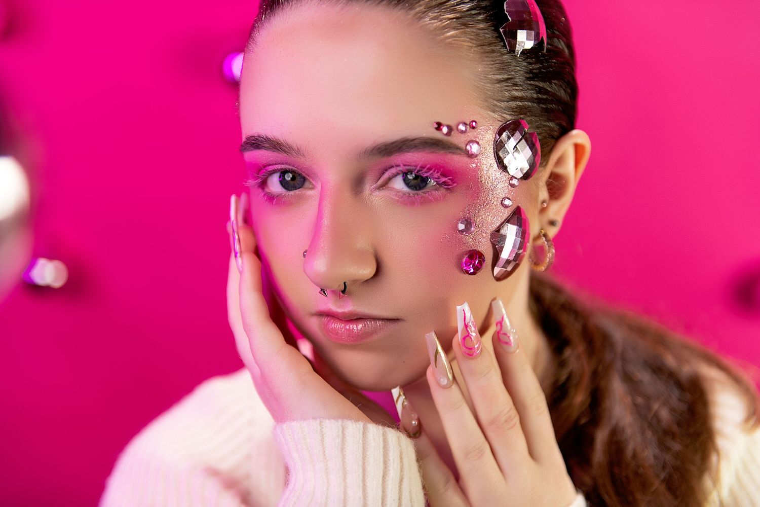 A collage of beauty portraits with pink makeup and creative face art against vibrant magenta backgrounds.