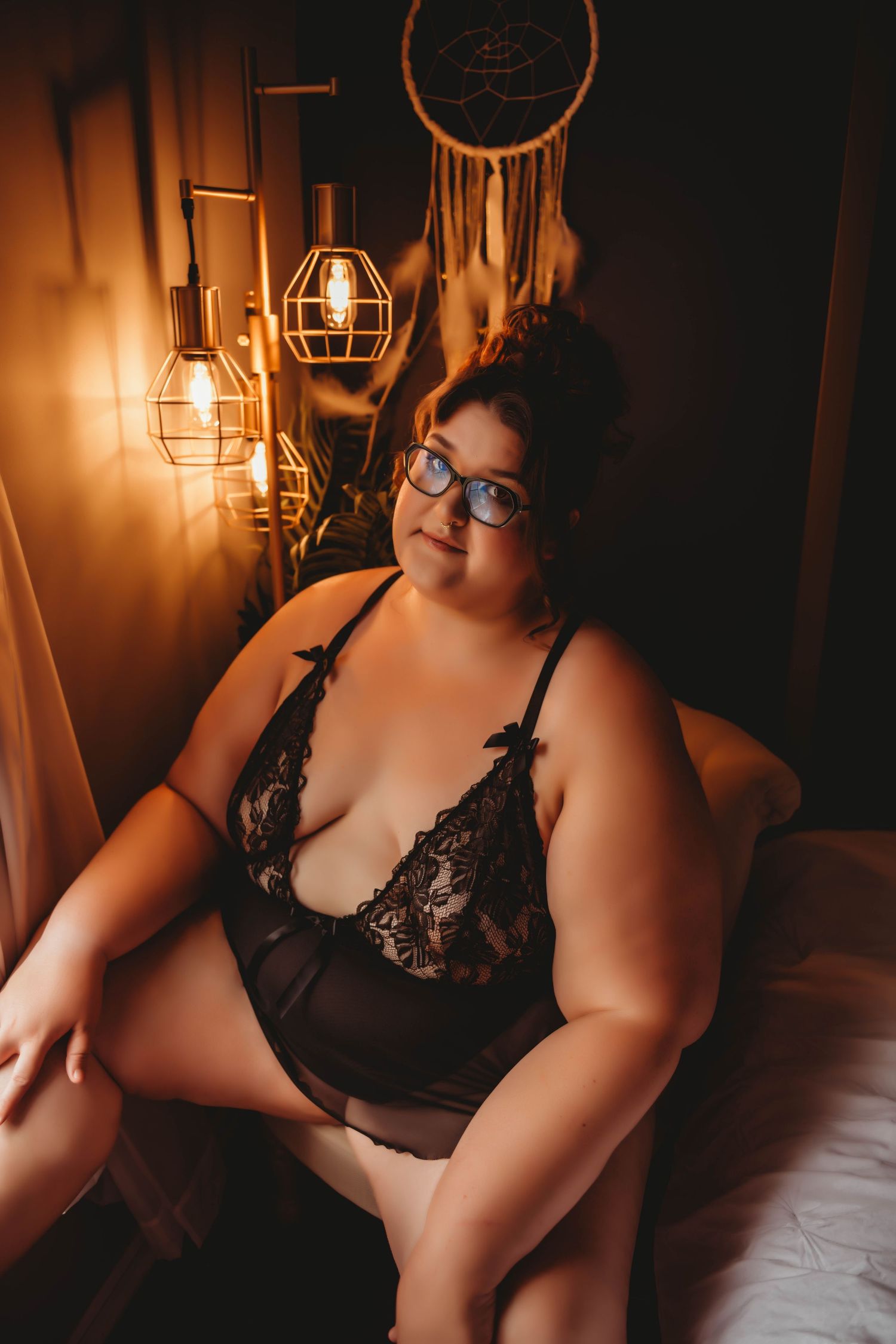 Intimate boudoir photography session in warm moody lighting with vintage-inspired black lingerie.