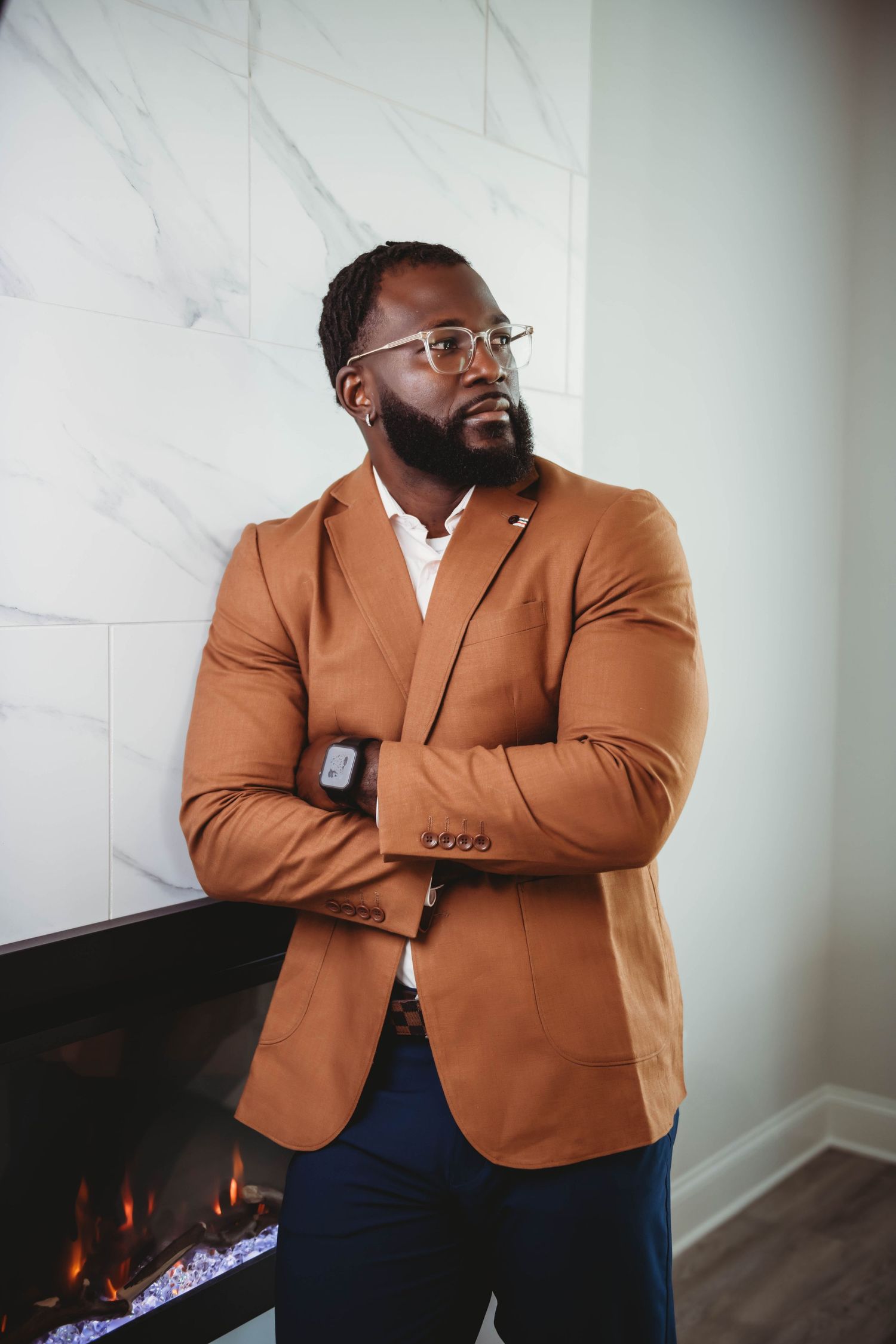 Stylish business portraits showing confidence in a tan blazer against marble walls.