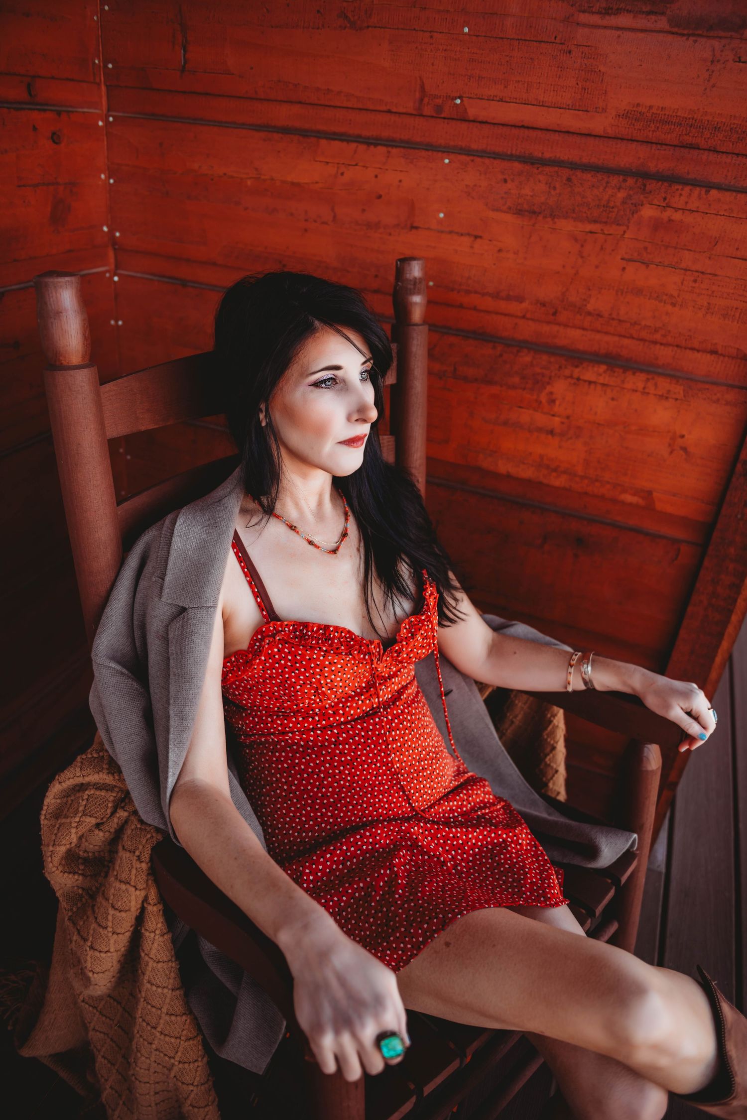 Vintage-inspired boudoir session with red polka dot dress and wooden cabin setting.