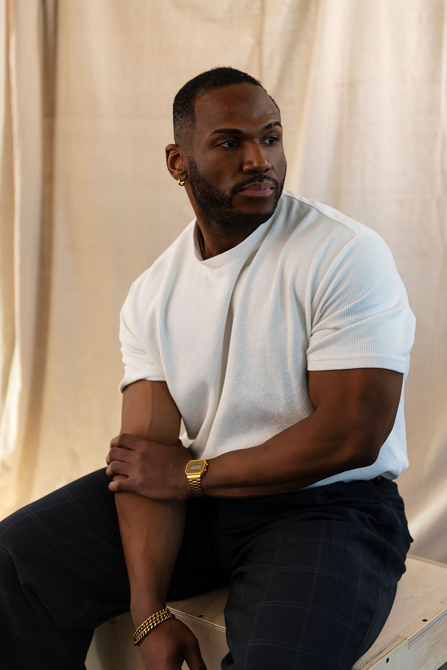 A series of four connected photos showing someone in a white t-shirt and dark pants sitting on a couch.