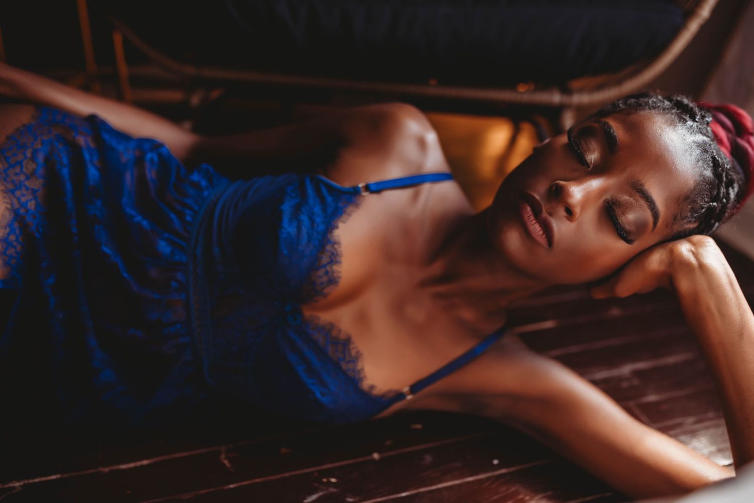 Moody boudoir photography in royal blue lingerie with dramatic shadow play.