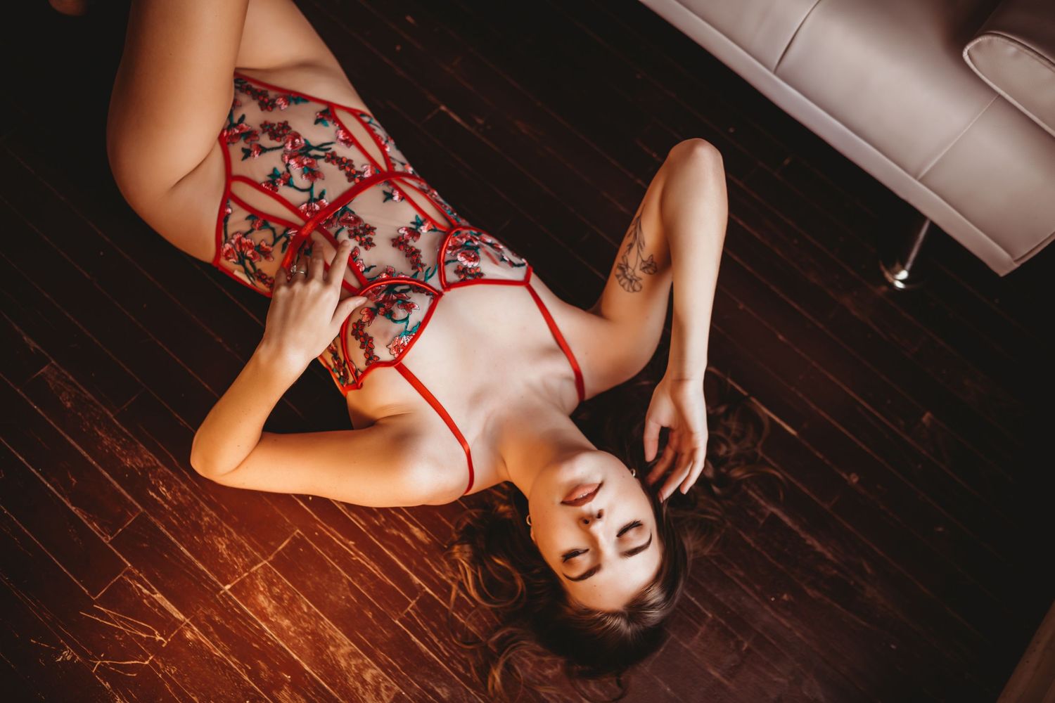 Intimate portrait session on wooden floor with dramatic lighting.