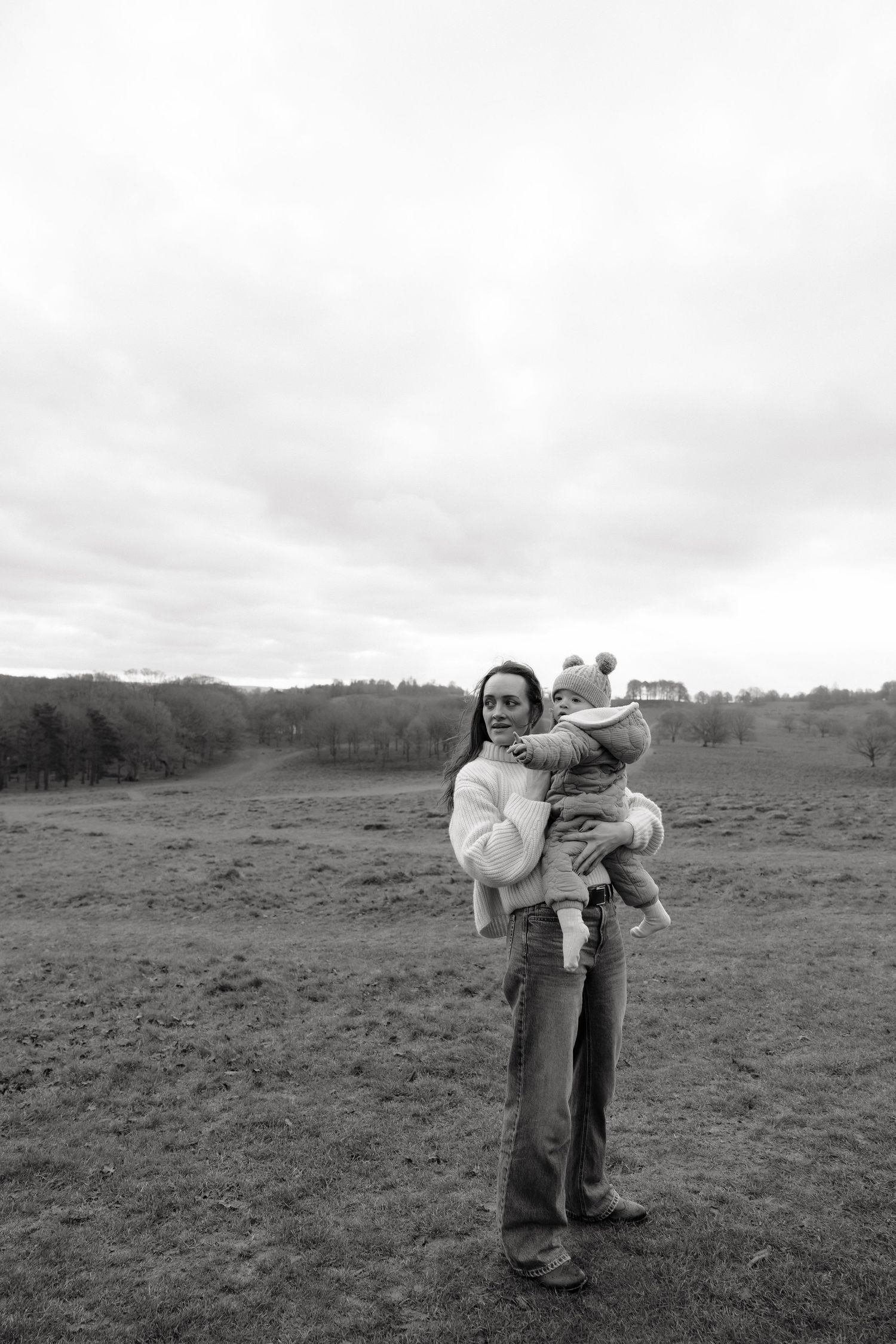 Black and white photo of a mother and her 15 month old gazing into the distance.
